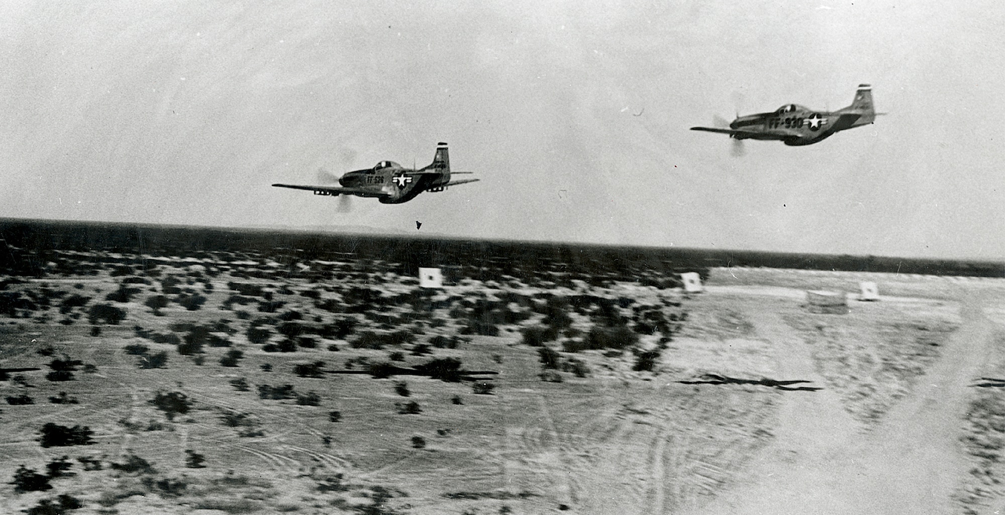 Two U.S. P-51 Mustangs conduct a low strafing pass over the Arizona desert at what is now the Barry M. Goldwater Range. (Courtesy photo)