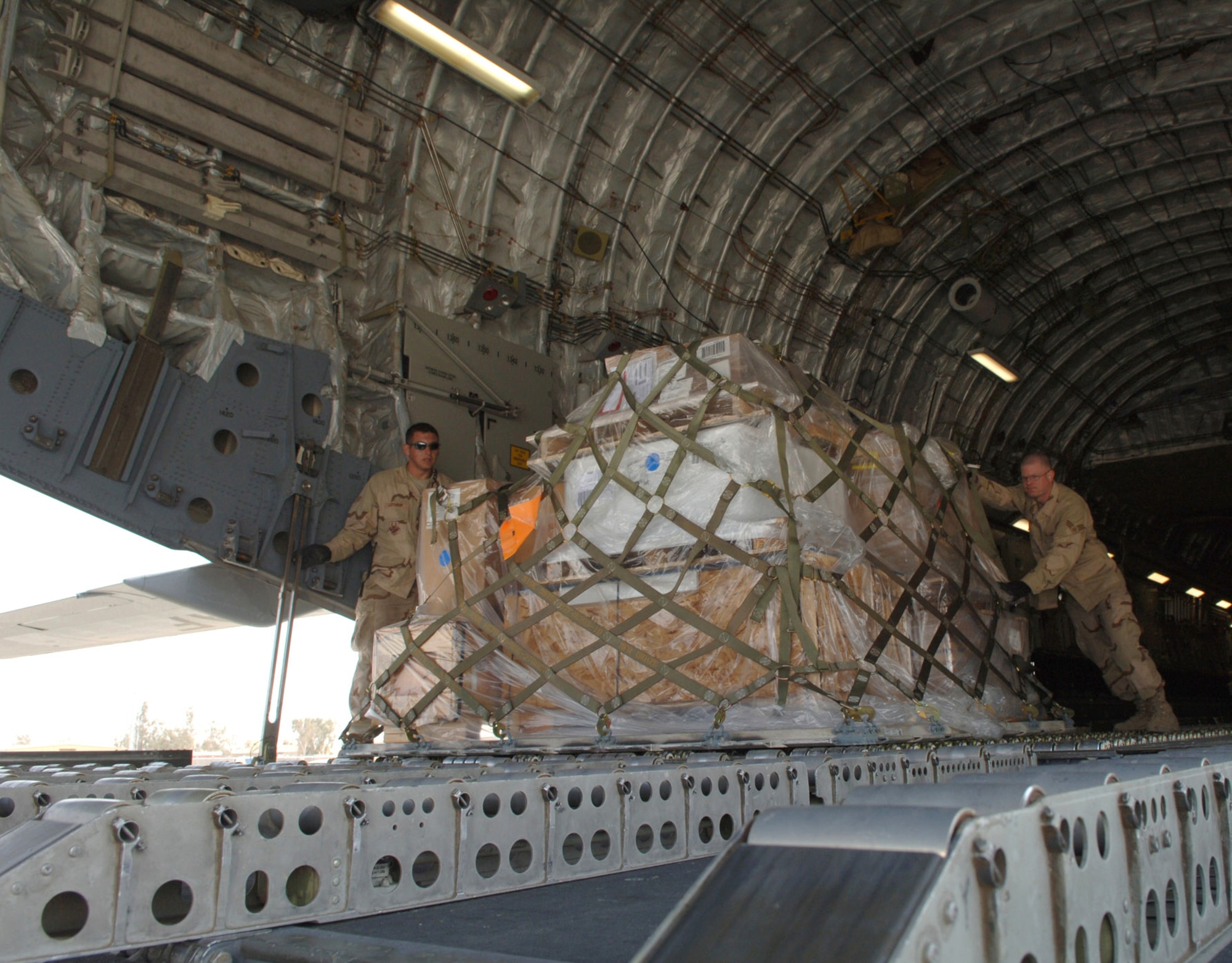 Airmen with the 332nd Expeditionary Logistics Readiness Squadron Aerial Port Flight push pallets off a C-17 Globemaster III March 14 at Balad Air Base in Iraq. Balad AB is the aerial port hub for all of Iraq and the busiest cargo aerial port in the Department of Defense. (U.S. Air Force photo/Airman 1st Class Nathan Doza) 