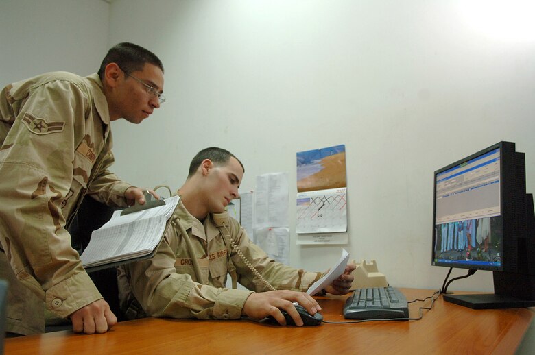 Airmen 1st Class Erick Campos and Nicholas Cross import cargo data into a computer program for processing March 14 at Balad Air Base in Iraq. Cargo processors also inspect pallets and loose cargo that comes through the base. The Airmen are assigned to the 332nd Expeditionary Logistics Readiness Squadron Aerial Port Flight. (U.S. Air Force photo/Airman 1st Class Nathan Doza)
