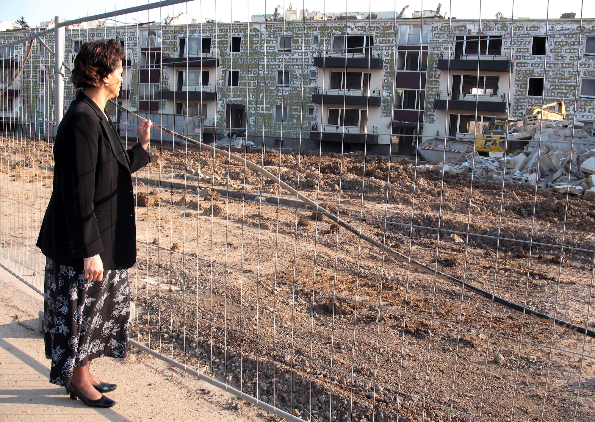 Denise Hastye watches as the old stairwell housing gets demolished March 30 at Spangdahlem Air Base, Germany. The Air Force is spending $83 million to demolish the old stairwell housing and building 139 new homes. Ms. Hastye is the base Housing Flight director. (U.S. Air Force photo/Senior Airman Christy Byers)
