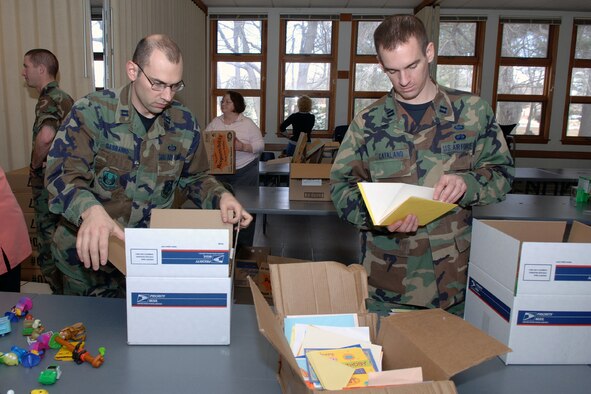 Capts. Marc Gasbarro and Christopher Catalano, both from the 551st Electronic Systems Wing, pack boxes with care during the Hanscom Troop Care Package drive.  (US Air Force Photo by Jan Abate)