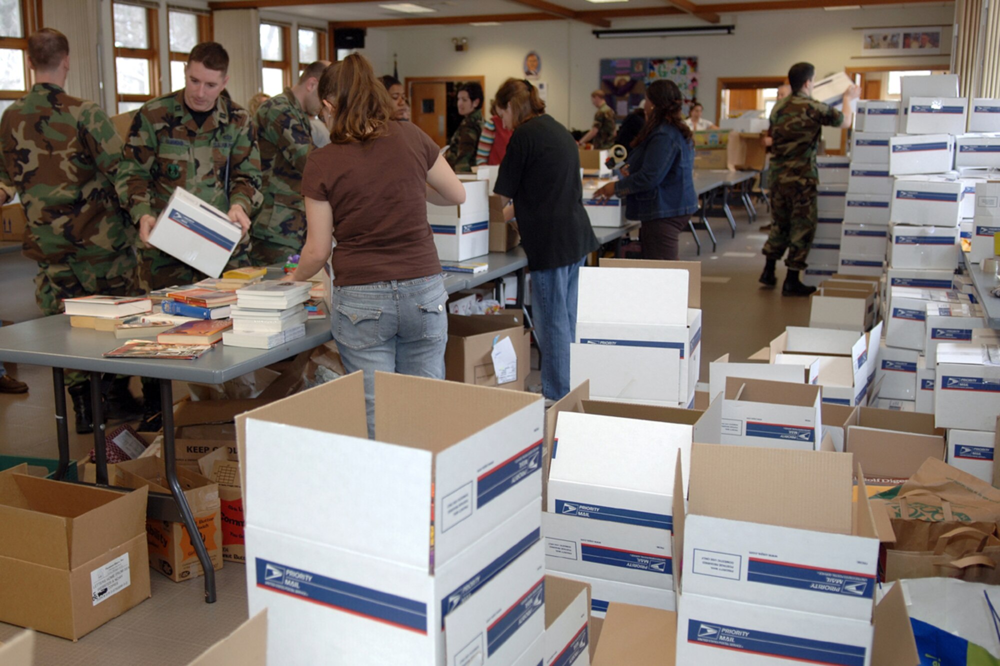 Hanscom personnel fill Troop Care packages at the Base Chapel Annex March 23. More than 700 boxes were shipped. (US Air Force Photo by Jan Abate)