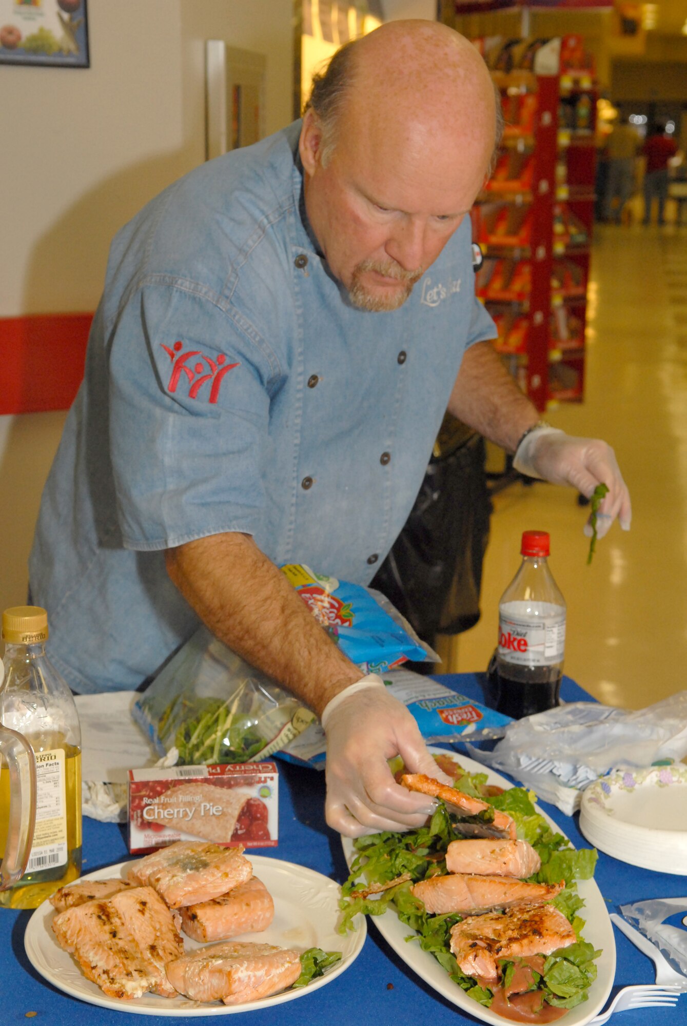 Chef Henry Weins, of the local TV cooking show “Let’s Eat,” adorns a plate of salmon salad while participating in this year’s base observance and celebration of National Nutrition Month (March) by providing a cooking demonstration Tuesday at the Goodfellow Commissary (U.S. Air Force photo by Staff Sgt. John Barton)
