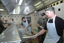 YOUNGSTOWN AIR RESERVE STATION, Ohio—In the foreground, Air Force Reserve Staff Sgt. Dan D'Annunzio cooks hamburger patties during the midday meal at the 910th Services Squadron Dinning Hall.  At his right, Airman 1st Class Tom Burke, Senior Airman Tony Behanna and Senior Airmen Asia Triplett assist in the food preparation for more than 1,400 reservists assigned to Youngstown Air Reserve Station. U.S. Air Force Photo/Tech. Sgt. Ken Sloat