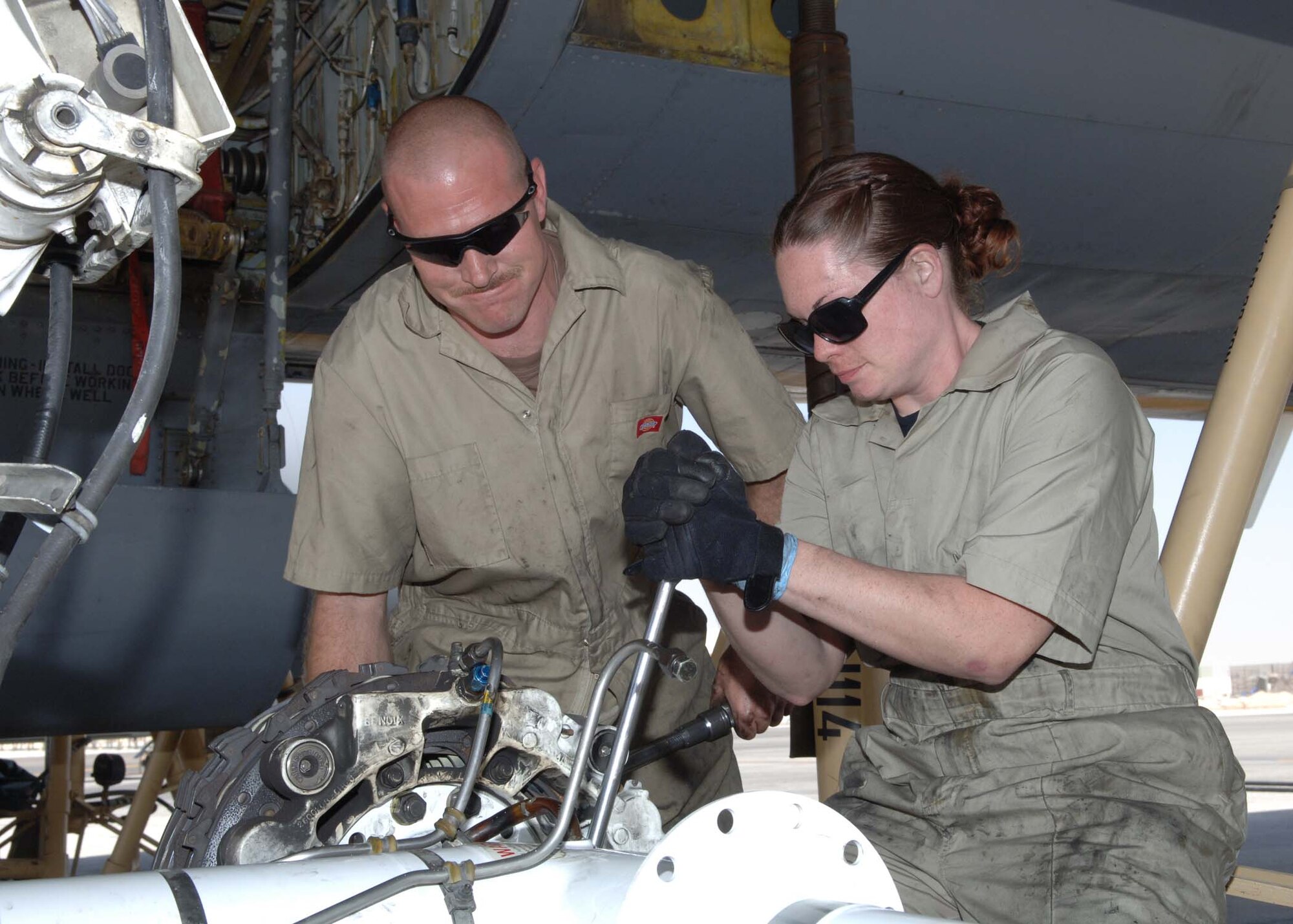Tech. Sgt. Paul Woodward, left, 22nd Maintenance Squadron, and Senior Airman Rebekah Metcalfe, 22nd Aircraft Maintenance Squadron, change a KC-135 main landing gear truck assembly March 1 at a deployed location. Both are McConnell members who are currently deployed to the 38th Expeditionary Aircraft Maintenance Squadron. (Air Force photo by Staff Sgt. Kyle Smith)