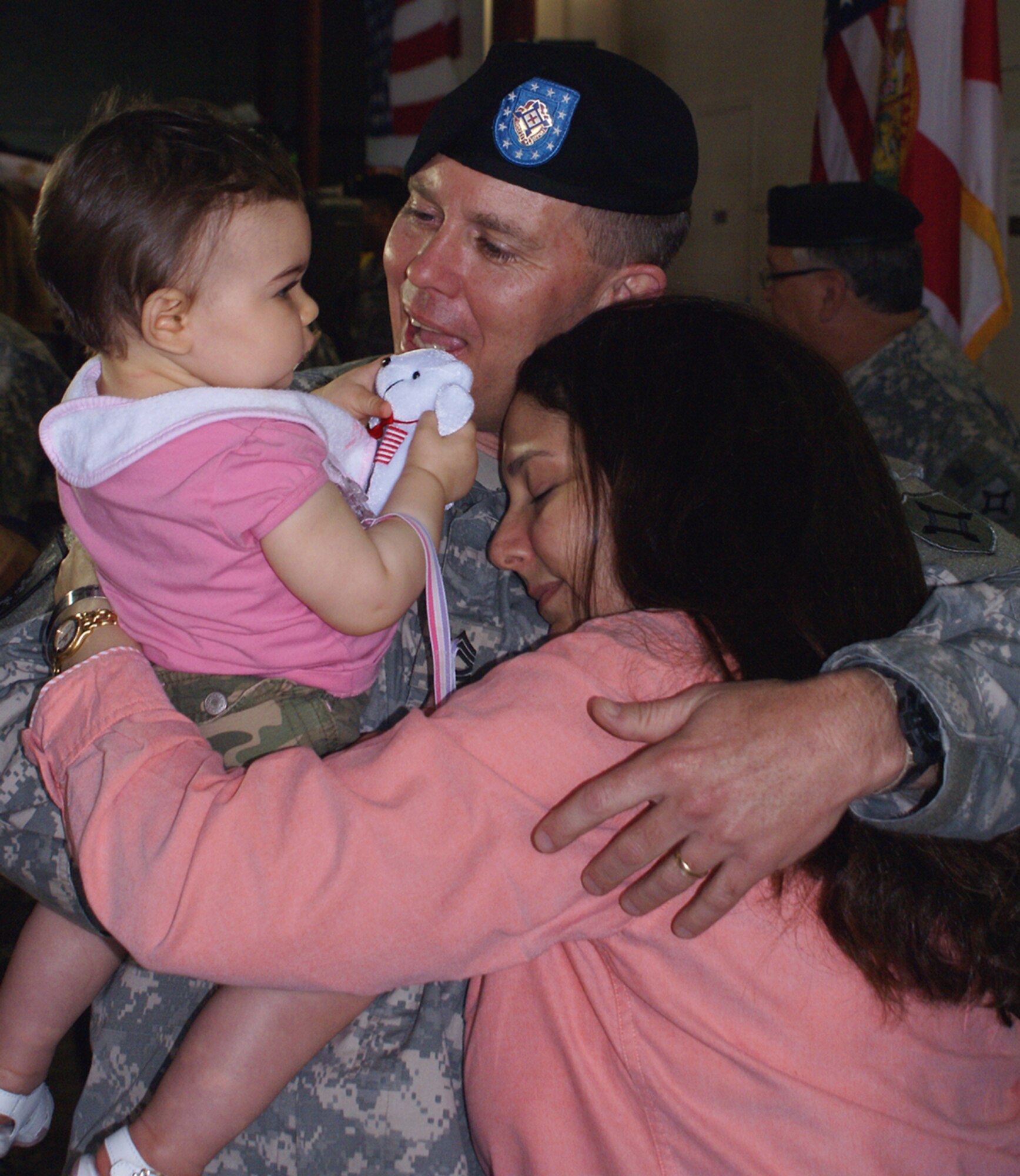 Sergeant First Class James Hester reunites with his wife, Michelle, and daughter, Carlee, after a year-long deployment to Afghanistan. Sergeant Hester is an Operations NCO with the 930th Army Liaison Team. The unit is a tenant of Homestead Air Reserve Base, Fla. During their deployment the team acted as liaisons between coalition, international and Afghan forces. (U.S. Air Force photo/Jake Shaw)
