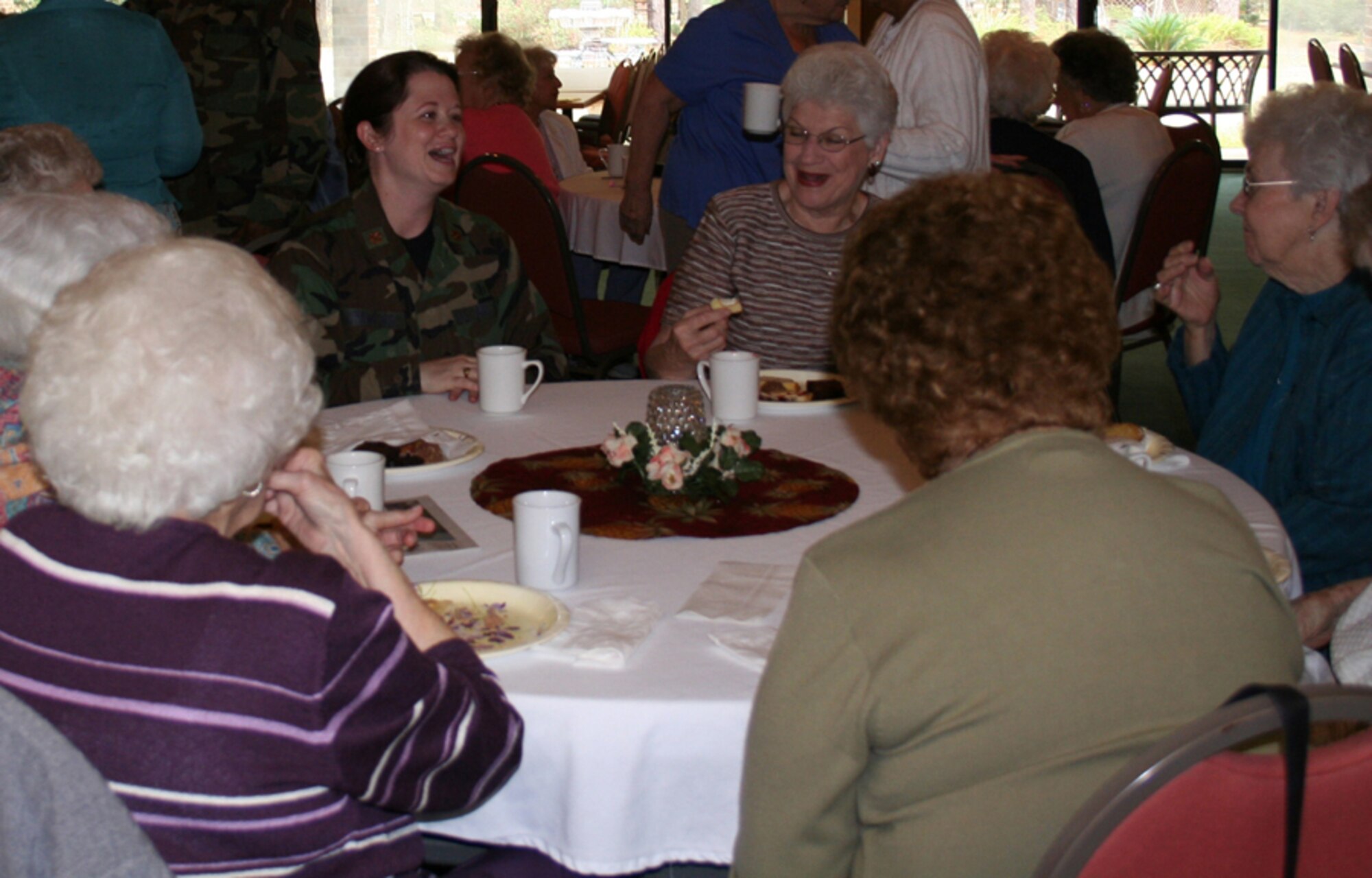 An Airman enjoys the company of Air Force Enlisted Village residents during an afternoon tea March 15. Many women Air Commandos took part in the tea and a workday, assisting the residents with small chores around the village. (U.S. Air Force photo by Jodi Jordan)