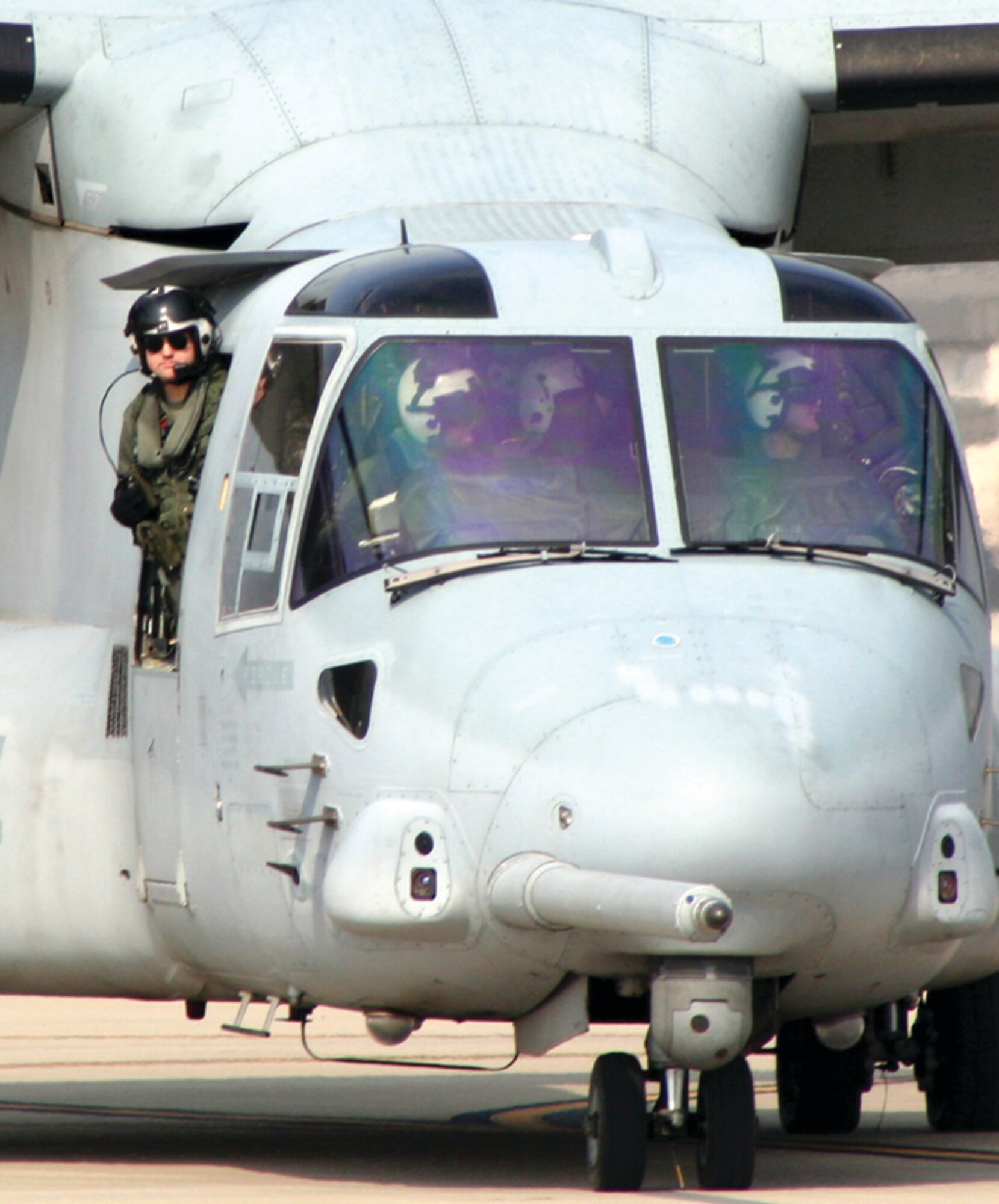 A U.S. Marine Corps flight engineer watches the ramp as the pilot manuevers the MV-22 Osprey to its place on the Hurlburt Field tarmac Tuesday. Eight MV-22s and more than 100 Marines are temporarily stationed here for the next week in order to use the Eglin Air Force Base ranges for exercises. (U.S. Air Force photo by Staff Sgt. Angela Shepherd)