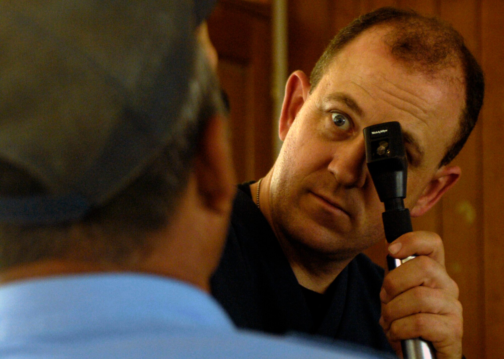 Lt. Col. John Blackburn examines a Nicaraguan volunteer policeman's eyes March 19 at a makeshift optometry clinic at Collegio San Gregorio. Inside the local school, 836 Nicaraguan patients were given free medical, dental and optometry care during a Medical Readiness Training Exercise as part of New Horizons-Nicaragua 2007. Colonel Blackburn is an optometrist with the California Air National Guard's 144th Medical Group. (U.S. Air Force photo/Staff Sgt. Jason T. Bailey)