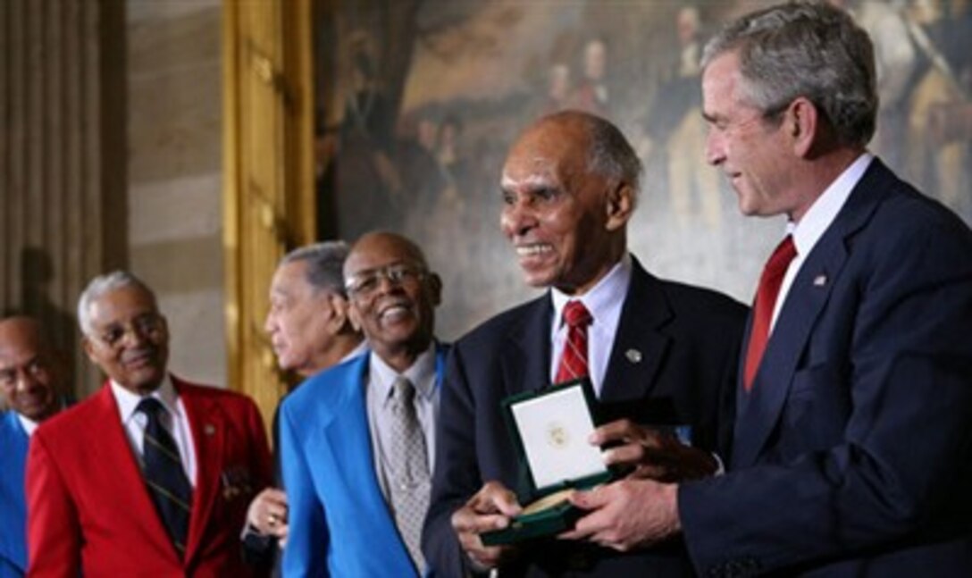 President George W. Bush presents the Congressional Gold Medal to Dr. Roscoe Brown Jr., during ceremonies honoring the Tuskegee Airmen March 29, 2007, at the U.S. Capitol. Brown, director of the Center for Urban Education Policy and university professor at the Graduate School and University Center of the City University of New York, commanded the 100th Fighter Squadron of the 332nd Fighter Group during World War II. 
