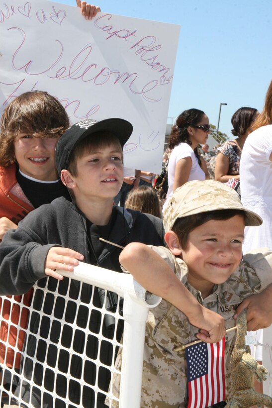 MARINE CORPS AIR STATION MIRAMAR, Calif. ? Logan ,6, Austin, 10, and Drew, 14 wait for their father Capt. Jeff Polson, headquarters company commander, Marine Wing Support Squadron 373, to turn in his weapon and come greet his family for the first time in almost eight months during homecoming celebration March 30.