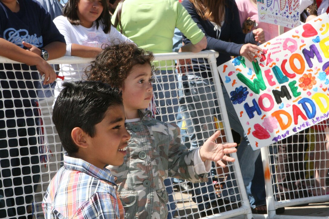 MARINE CORPS AIR STATION MIRAMAR, Calif. ? Amilie Rodriguez, 2, along side her cousin Maithem Alfuraiji, 10, waves to her father as he turns in his weapon before he can go visit his family at a homecoming celebration March 30.