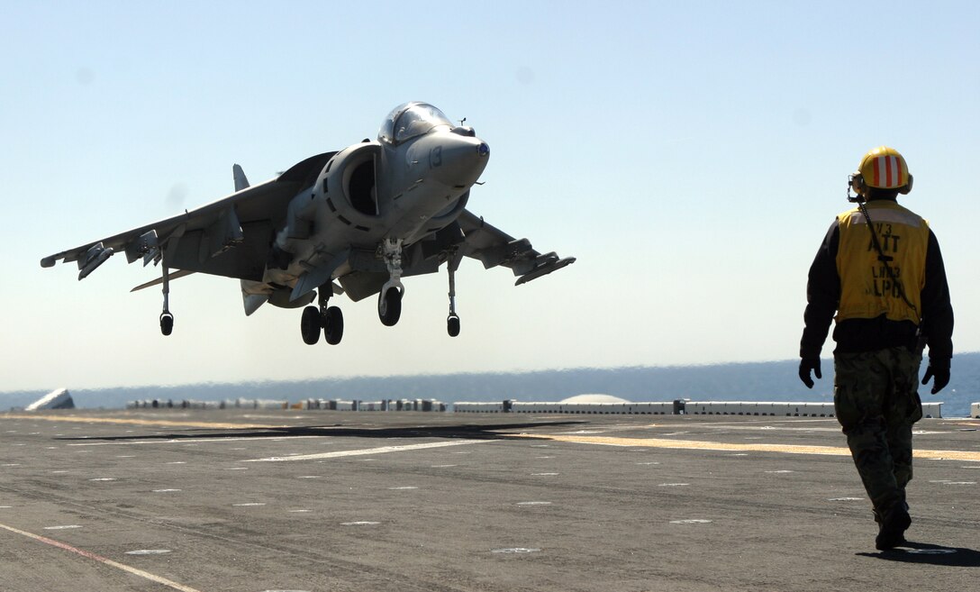A landing supervisor watches as an AV-8B Harrier with Marine Medium Helicopter Squadron 261 (reinforced) executes its distinctive vertical landing on the flight deck of the U.S.S. Kearsarge during carrier qualifications March 30, 2007. HMM-261 (rein) is scheduled to deploy as the Aviation Combat Element for the 22nd Marine Expeditionary Unit later this year. (Official Marine Corps photo by Sgt. Matt Epright)