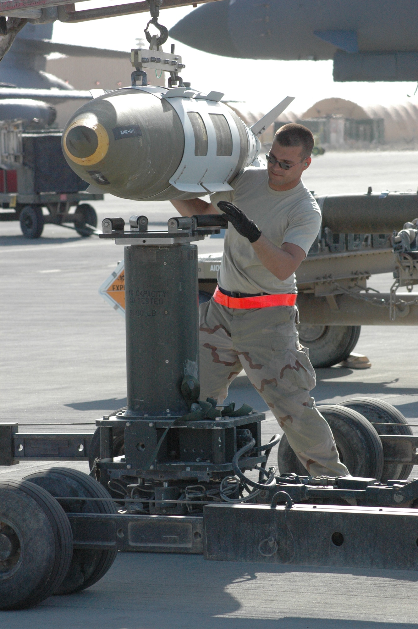 Airman 1st Class Kenneth Nealis, 379th  Expeditionary Aircraft Maintenance Squadron weapons load crew member, transfers a 2,000 pound GBU-31 Joint Direct Attack Munition from one lift truck to another for transport and loading onto a B-1B Lancer. (Photo by Senior Airman Erik Hofmeyer)