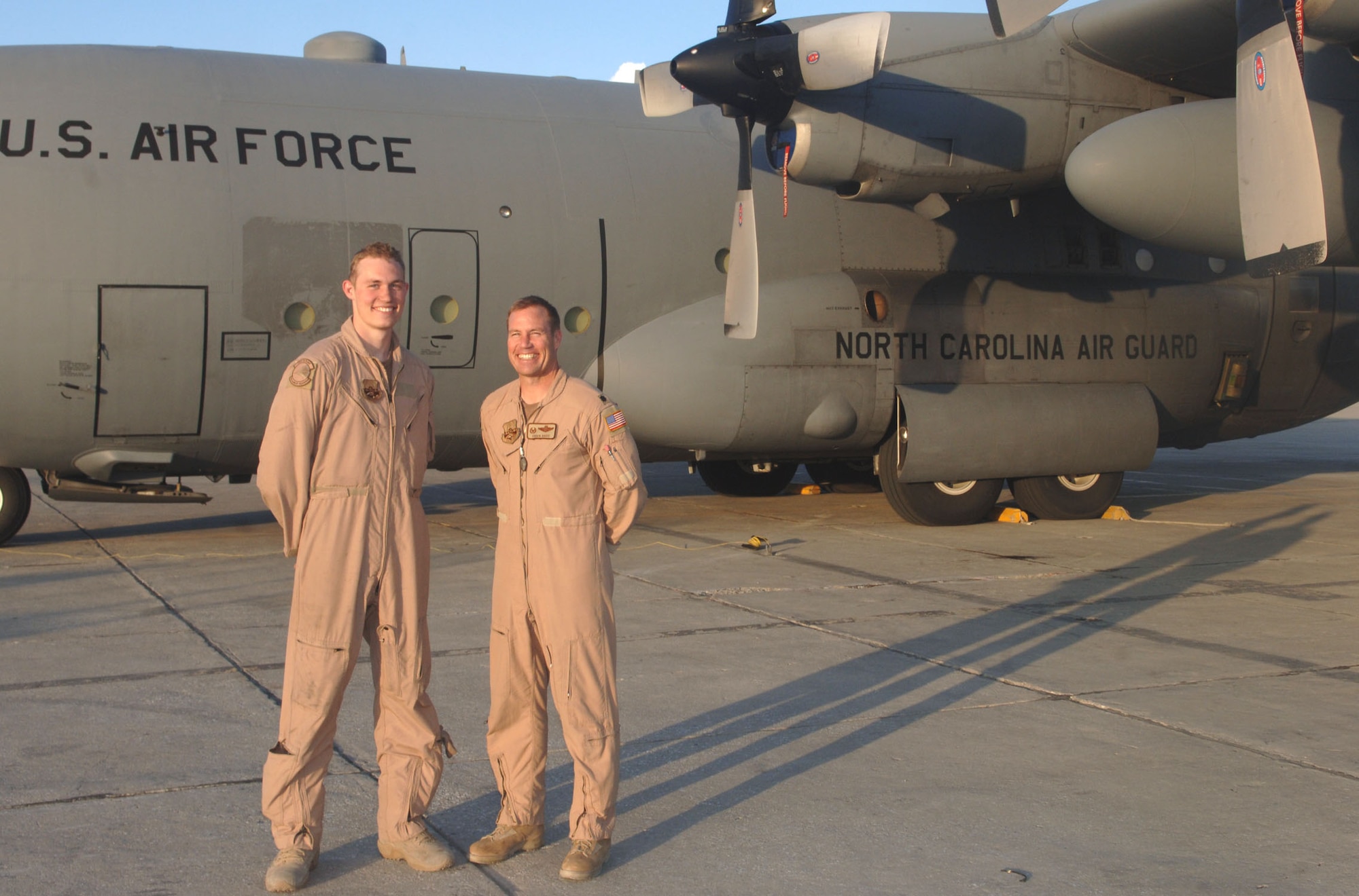 Senior Airman Chuck Davis and his father, Lt. Col. Chuck Davis, stand in front of one of their squadron's C-130s. Airman Davis is a loadmaster, and Colonel Davis is a navigator; both are members of North Carolina's Air National Guard deployed to the 774th Expeditionary Airlift Squadron. (U.S. Air Force photo/Capt. Travis B. Tougaw)