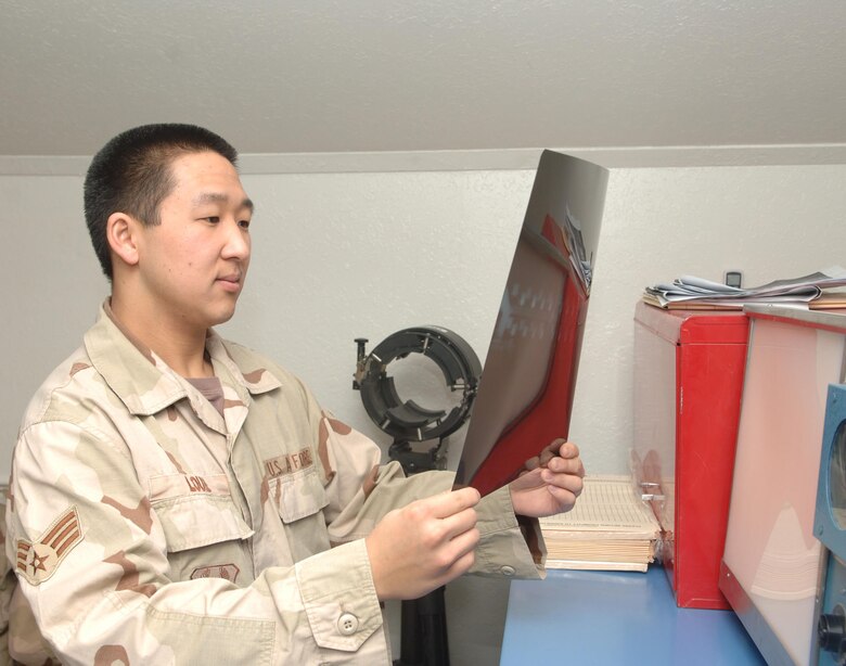 Senior Airman Kevin Louie of the 455th Expeditionary Maintenance Squadron's nondestructive inspection team checks a radiograph of the wing section of an F-15E Strike Eagle. (U.S. Air Force photo/Staff Sgt. Kevin Tomko)