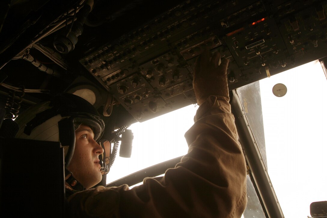 Capt. Justin W. May, a CH-46E Sea Knight helicopter pilot from Marine Medium Helicopter Squadron-264 (Reinforced), 26th Marine Expeditionary Unit, performs pre-flight checks during a division leader qualification evaluation at Udairi Range, Kuwait, May 1, 2007.  The evaluation challenged  May's ability to manage not only his aircraft but an additional two CH-46s in a simulated real-world scenario.  (Official USMC photo by Cpl. Jeremy Ross) (Released)