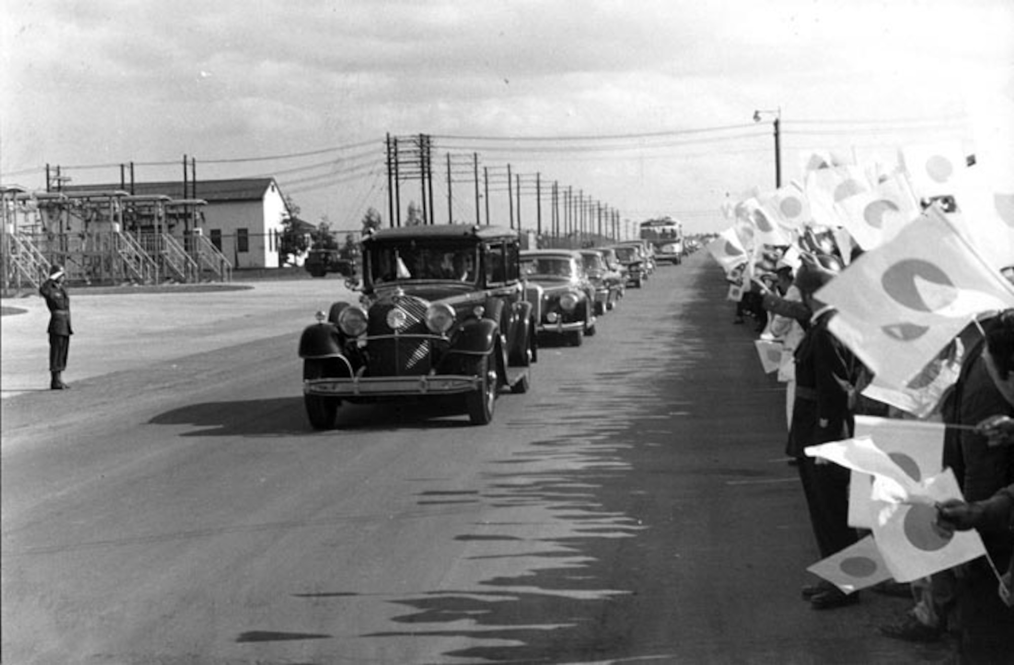 630522-MISAWA AIR BASE, Japan -- The Imperial royal motorcade carrying the Emperor and Empress heads down Friendship Boulevard toward the Misawa AB flightline.  (Photo by Irv Silberman)