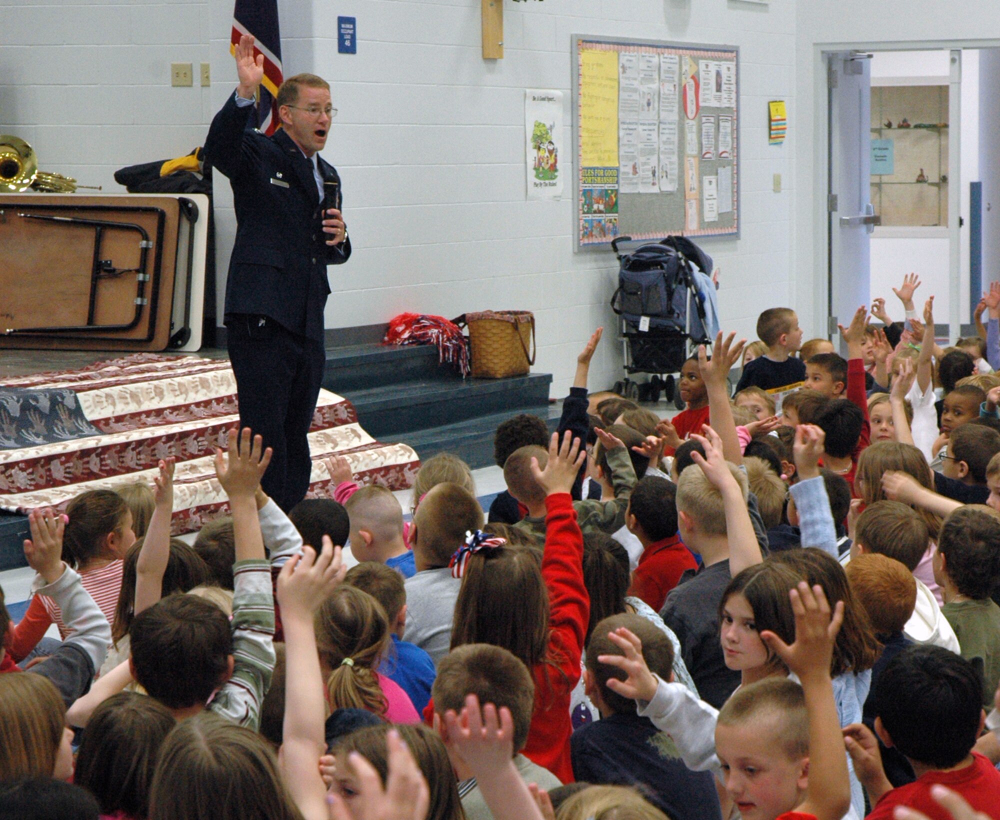 Col. Brian Hayes, 90th Medical Group commander, asks children at Freedom Elementary in Cheyenne Monday to raise their hands if one of their parents is in the military. Freedom Elementary held a pep rally to honor the Month of the Military Child. Children at the rally received dog tags and American flags (Photo by 2nd Lt. Lisa Meiman).