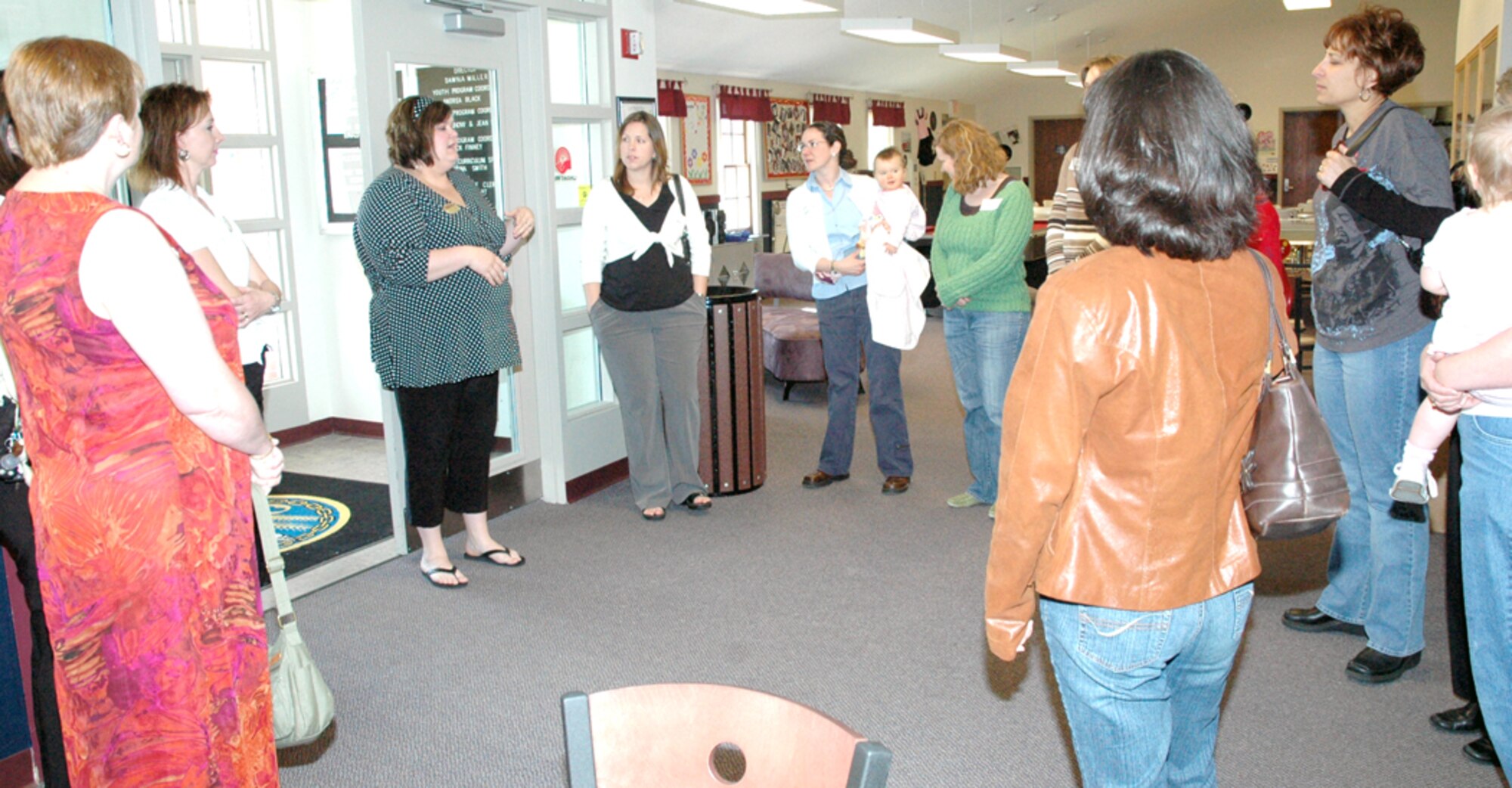 Andrea Black, 90th Services Squadron, talks to Warren spouses about the youth center during the all-ranks spouses tour April 20. Spouses toured facilities and services offered to Warren families during the day-long event. The Warren Airman and Family Readiness Center held the tour, which featured places like the teen center, chapel, A&FRC and the child development center (Photo by Airman Alex Martinez).