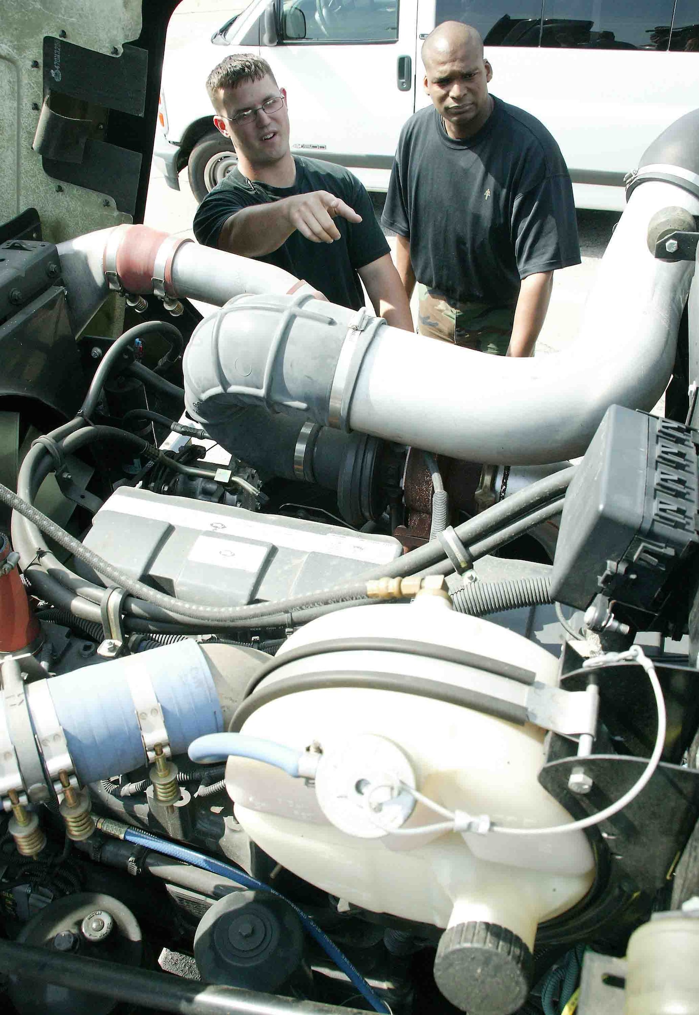 SHAW AIR FORCE BASE, S.C. -- Staff Sgt. Stephen Zuelke (left), 20th Logistics Readiness Squadron vehicle technician, and Tech. Sgt. Spellmon Quinn, 20th LRS vehicle technician,  discuss the location of the fuse box on an R-11 hybrid refueling vehicle April 25. The environmental-friendly hybrid is the only one of its kind in the Air Force. The 72,000-pound hybrid is undergoing a one-year test at Shaw to see how much money it is saves on fuel, maintenance and other cost measurements. (U.S. Air Force photo/Senior Airman John Gordinier)