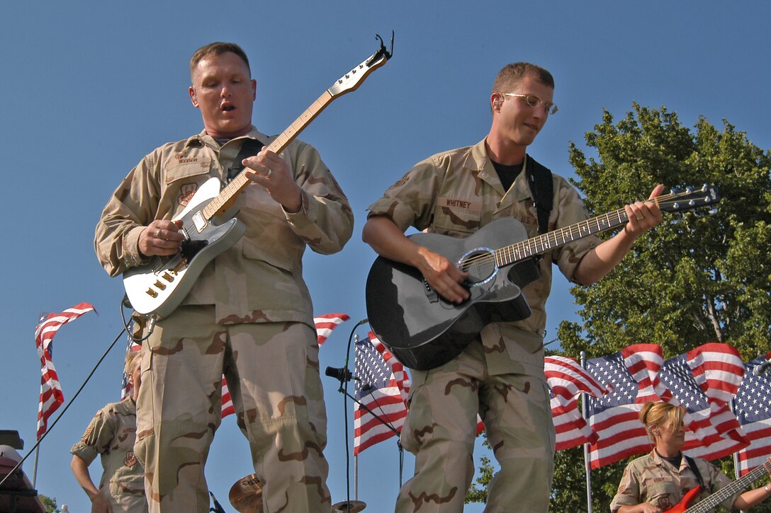 OFFUTT AFB - Master Sgt Jimmy Weber and Senior Amn Clint Whitney take the crowd on a guitar "ride" during one of the band's "Sundays on Parade" concerts.