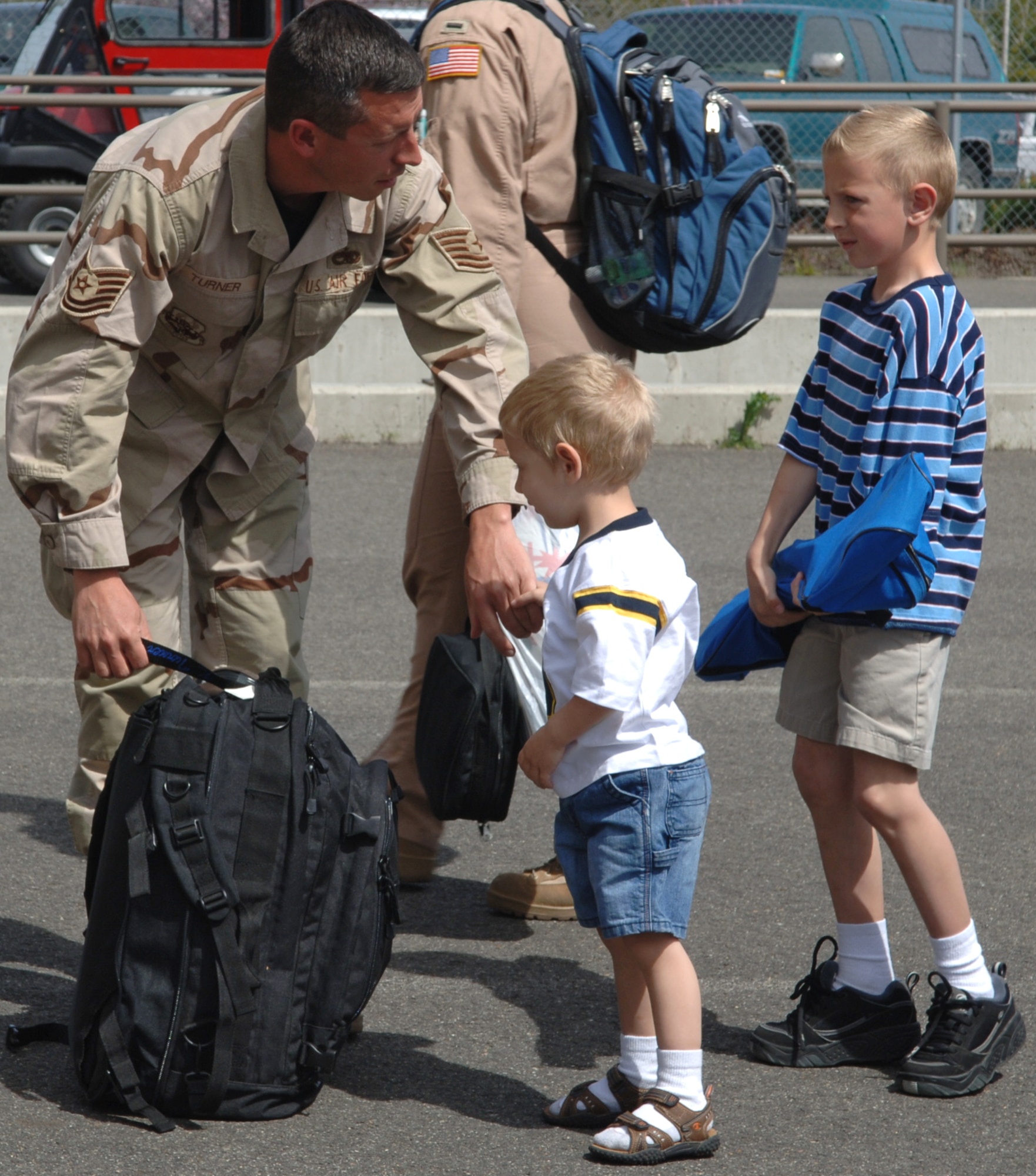 FAIRCHILD AIR FORCE BASE, Wash. – Kole and Kade Turner stick close to their dad, Tech. Sgt. Kevin Turner, after going months without seeing him. Sergeant Turner returned with approximately 40 other deployers from Manas Air Base, Kyrgyzstan. (U.S. Air Force Photo/Airman 1st Class Jocelyn Ford)
