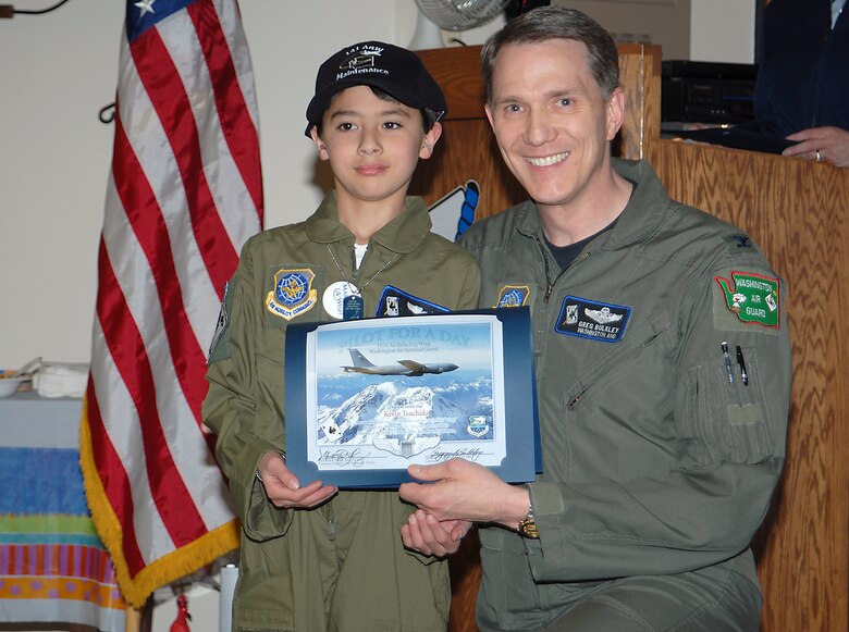 FAIRCHILD AIR FORCE BASE, Wash. -- Kevin Tsuchinda receives his Pilot for a Day certificate from Col. Greg Bulkley, 141st Air Refueling Wing commander, April 18. These two boys were treated to an orientation through the 141st ARW’s Pilot for a day Program. (U.S. Air Force photo/Senior Master Sgt. Bob Thackston)