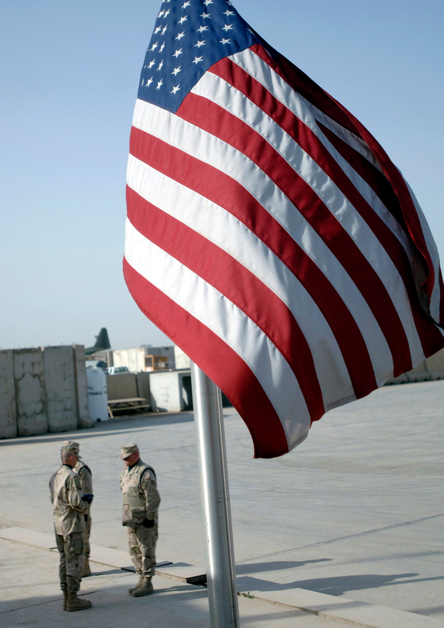Staff Sgts. Andrew Keller and Jody Nitz and Maj. Shannon Kolnsberg conduct an official flag raising and folding ceremony April 21 in Baghdad, Iraq. The Sather Air Base Honor Guard raised and folded 23 U. S. flags. The three Airmen are assigned to the 447th Expeditionary Medical Squadron. (U.S. Air Force photo/Tech. Sgt. Cecilio M. Ricardo Jr.)