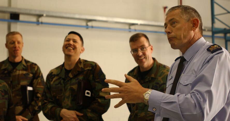 Warrant Officer Lindsey Morgan, right, from the British Royal Air Force talks to Airmen inside the 100th Maintenance Squadron hanger while (from left) RAF Mildenhall Command Chief Master Sgt. Michael Warner, Chief Master Sgt. Gregory Blue, and Senior Master Sgt. John Van Duser from the 100th MXS listen April 23, 2007. (U.S Air Force photo by Airman Brad Smith) 