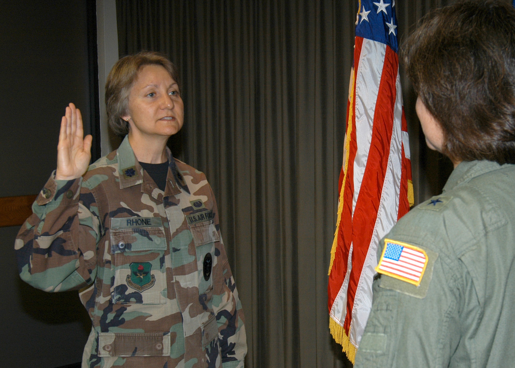 Air Force Recruiting Service Staff Judge Advocate Lt. Col. Karen Rhone states the Oath of Enlistment during a ceremony today on Randolph Air Force Base, Texas. National Law Day, held annually May 1, celebrates the rule of law, of which, in 1789, the first session of the first Congress enacted the first U.S. law establishing the Oath of Office for civilian and military offices. Brig. Gen. Suzanne Vautrinot, AFRS commander, administered the oath during the ceremony. Lieutenant Colonel Rhone's father, OB Hearne, a World War II veteran, had the honors of helping his daughter pin on her new rank in a hometown ceremony April 29 in Loving, Texas. (U.S. Air Force photo by Staff Sgt. Jennifer Lindsey)