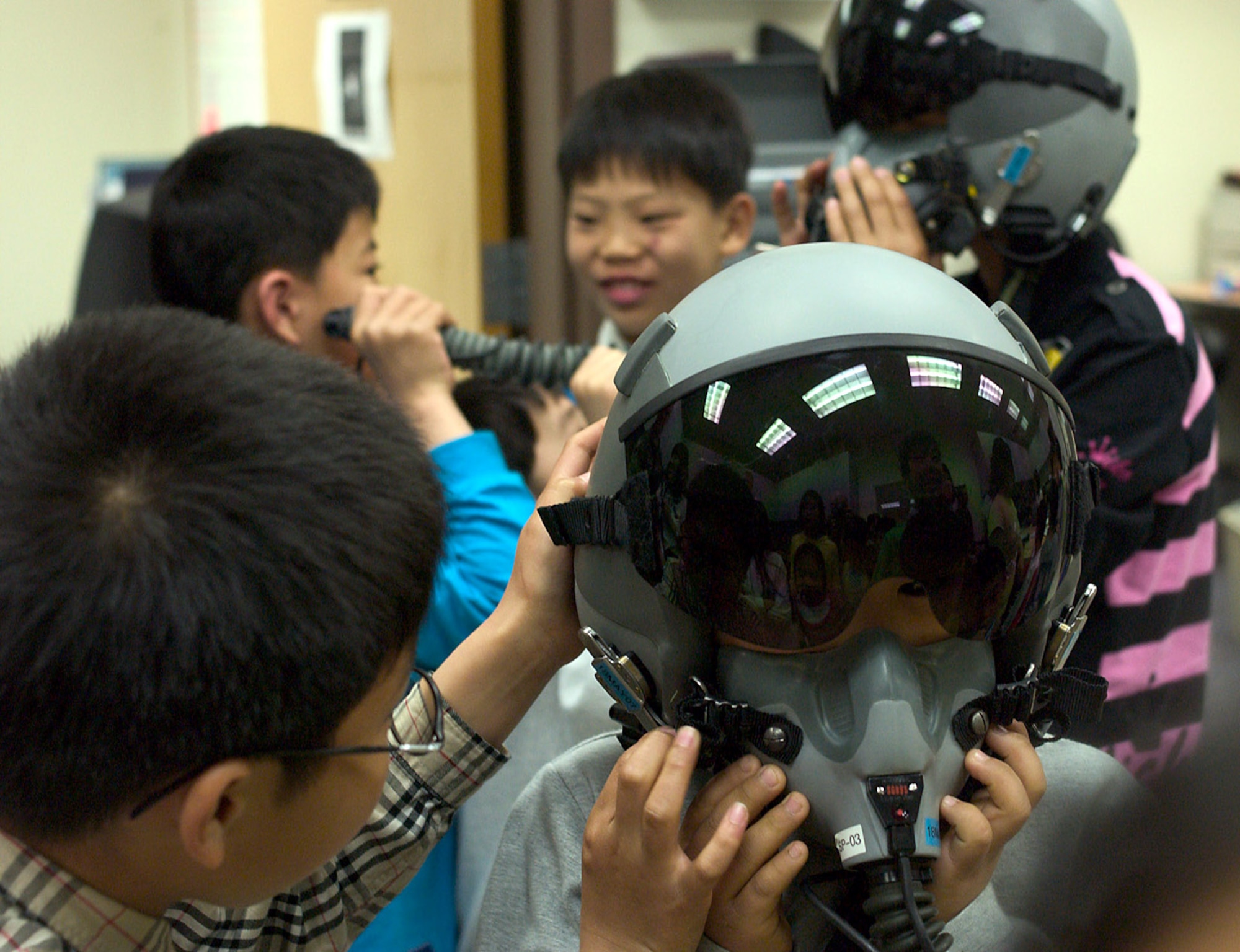 Children from a Gunsan City orphanage toy around with fighter pilot helmets during a visit to the 35th Fighter Squadron April 27 at Kunsan Air Base, South Korea. Airmen of the 35th FS hosted the orphanage as part of the 8th Fighter Wing's Good Neighbor Program and commitment to supporting the community. The 35th FS is one of two F-16 Fighting Falcon squadrons assigned to the 8th Fighter Wing. (U.S. Air Force photo/Senior Airman Barry Loo) 
