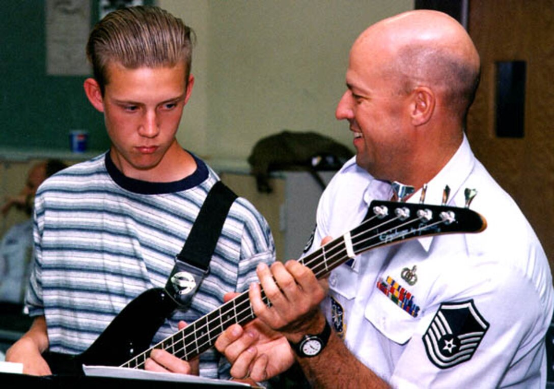 MSgt (ret) Scott Webring, from the USAF Academy Band, helps a bass student during a recent clinic with the Falconaires jazz band as part of the education outreach program.