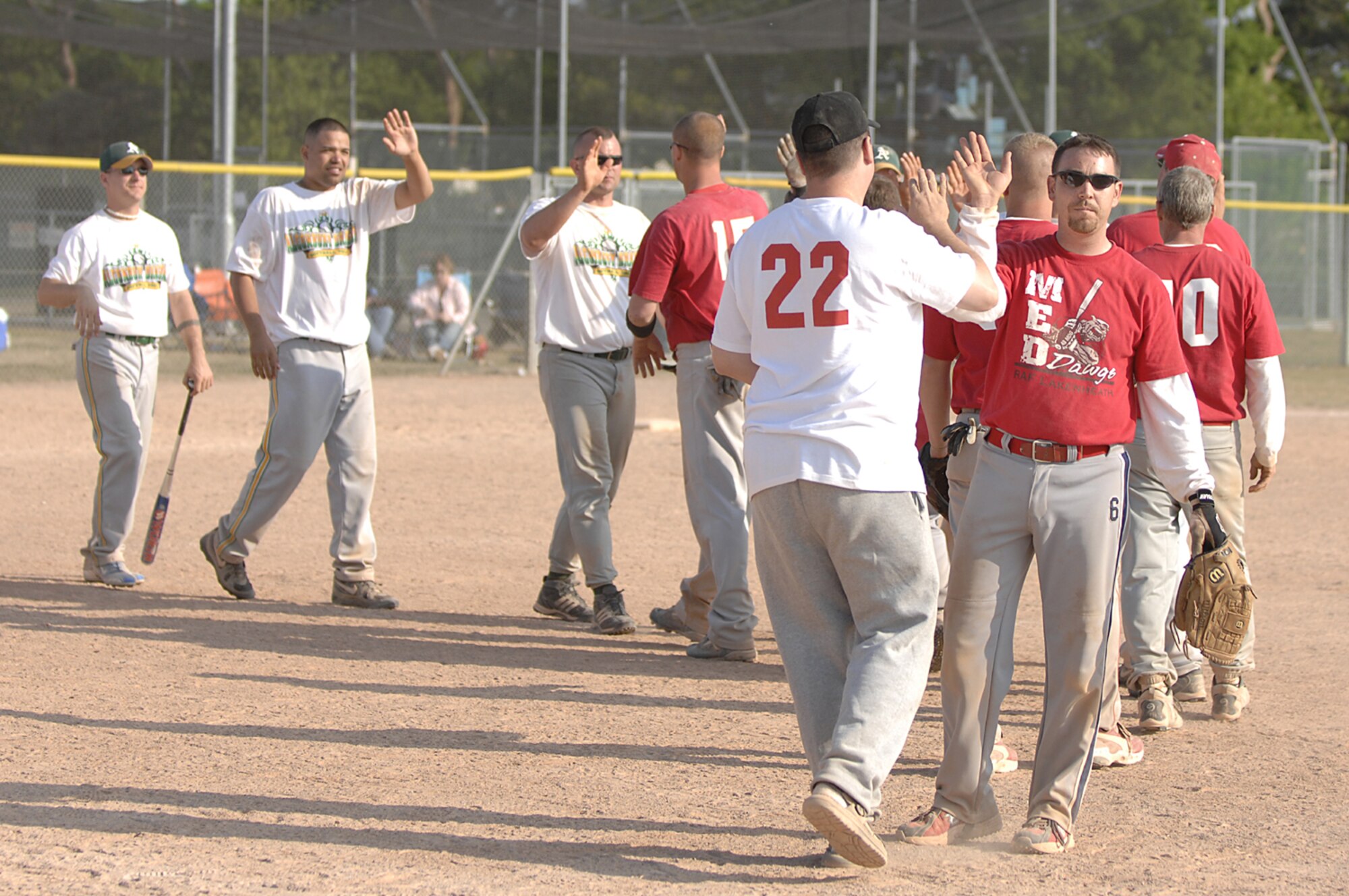 The 48th Medical Group and RAF Alconbury softball teams congratulate each other after a hard fought battle after the championship game of a Medical Group Top 3 softball tournament at RAF Lakenheath on April 29. The 48th Medical Group defeated RAF Alconbury in two straight games to win the double elimination tournament. (U.S. Air Force photo by SrA Brian J. Ellis)