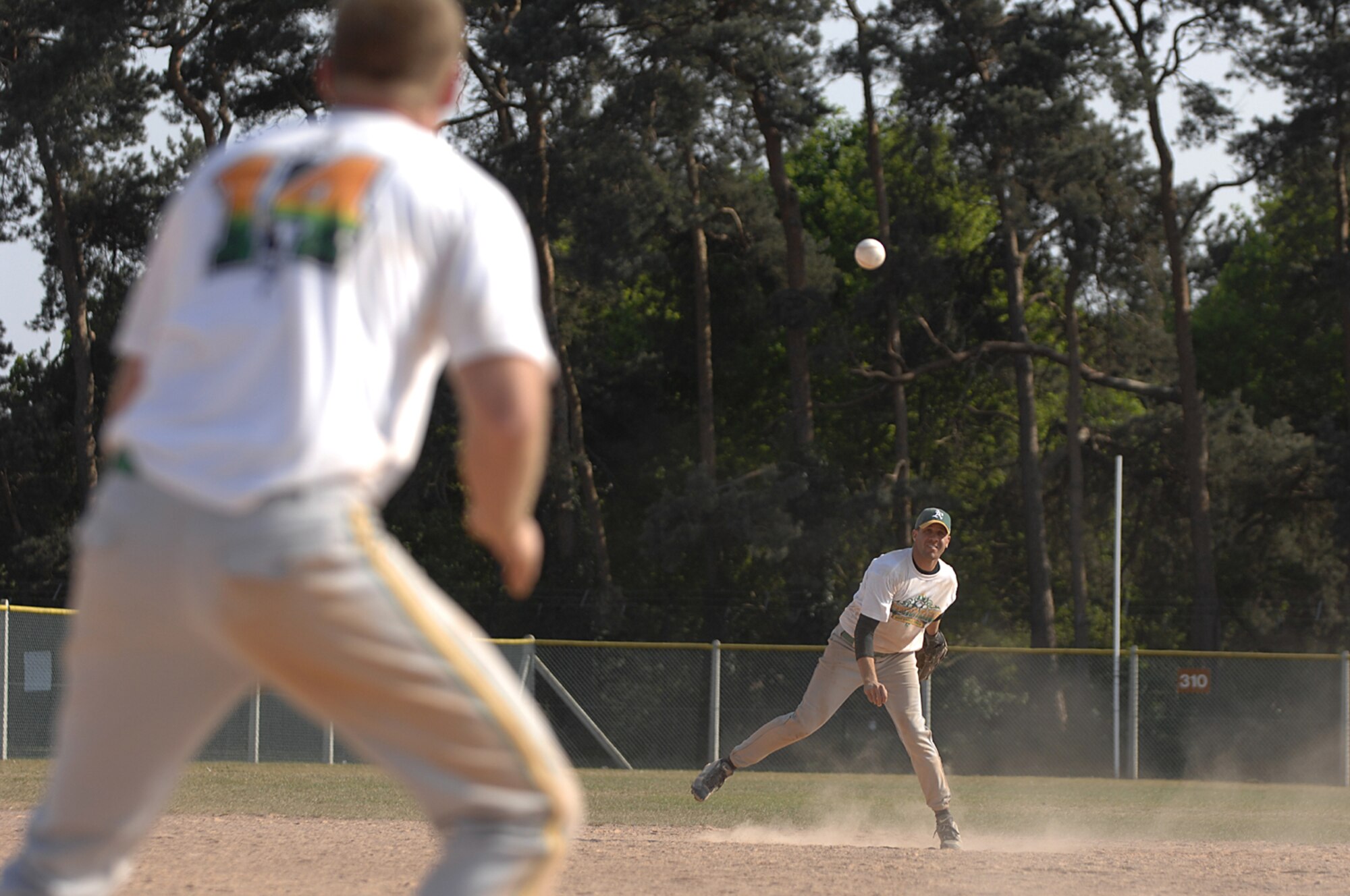 Sean Simler, RAF Alconbury, makes a throw to first base to Greg Brittnacher, RAF Alconbury, at RAF Lakenheath on April 29, 2007. The 48 Medical Group defeated RAF Alconbury in two straight games to win the double elimination tournament. (U.S. Air Force photo by SrA Brian J. Ellis)