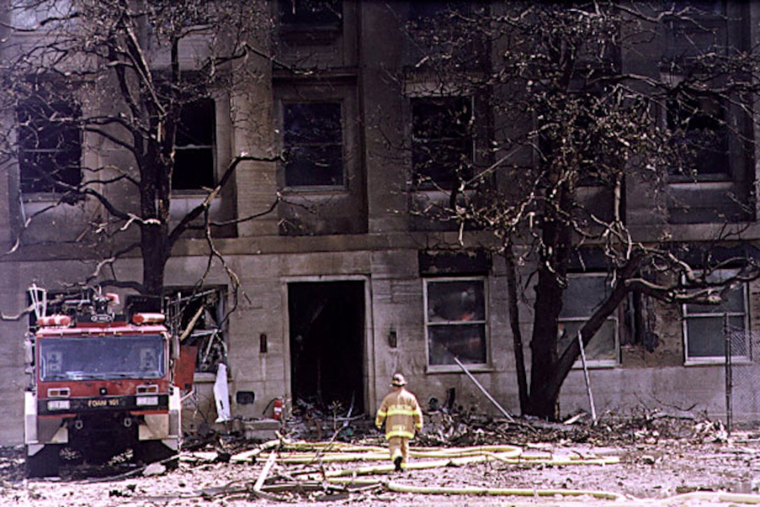 Rescue teams and fire departments aid  Pentagon workers Sept. 11, 2001, after the building was set  ablaze by a plane crash. Photo by Paul Disney, USA.