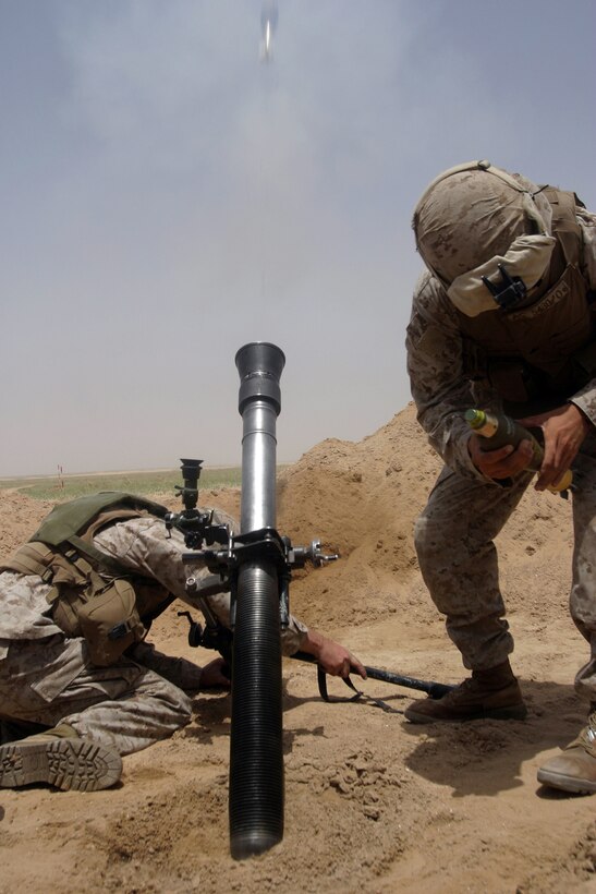 Marines from 81mm Mortar Platoon, Battalion Landing Team 2/2, 26th Marine Expeditioanry Unit, take cover as they fire a mortar during live-fire training at Udairi Range, Kuwait, May 2, 2007.  The training marked the second time during the MEU's current deployment that the platoon has fired its main weapon system.  (Official USMC photo by Cpl. Jeremy Ross) (Released)