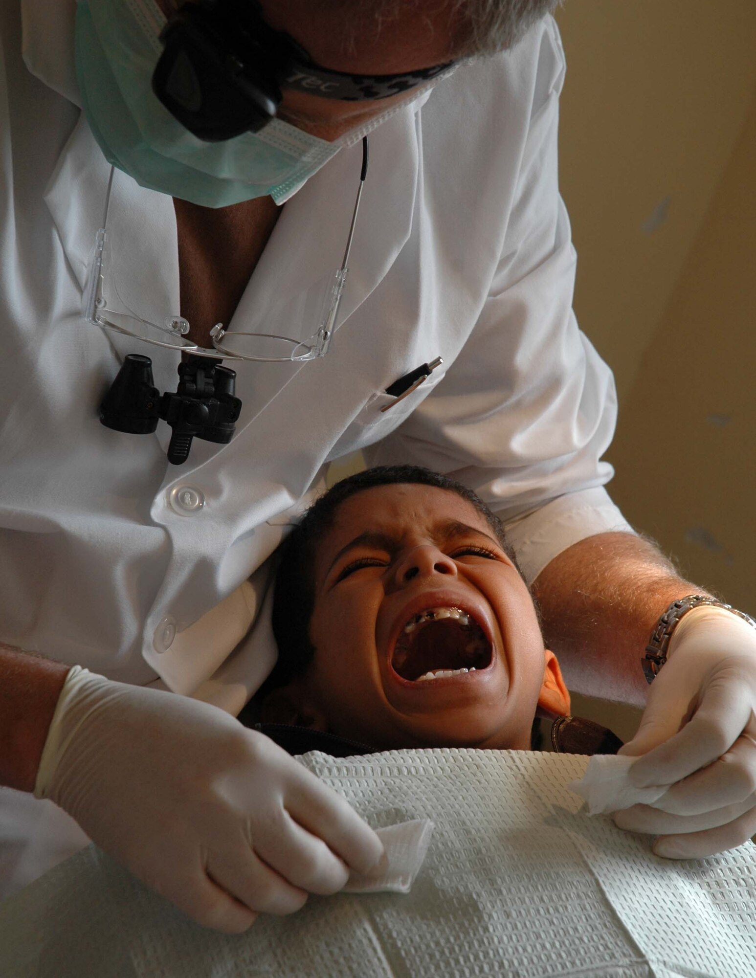 A small boy relunctantly opens his mouth for Maj. Brent Dupper, a dentist with the 452nd Aerospace Medicine Squadron at March AFB, Calif. Major Dupper joined a team of 944th Medical Squadron personnel from Luke AFB, Ariz., to participate in humanitarian assistance at six sites in Morocco. (U.S. Air Force photo/Tech. Sgt. Susan Stout)