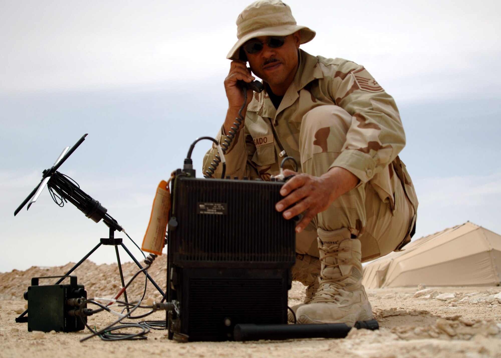 Master Sgt. Mike Rosado tests a multi-band satellite-communications-capable tactical radio used for secure tactical communications near Al Asad Air Base, Iraq. The radio is used for contingency operations and can be used nearly anywhere on the earth's surface. Sergeant Rosado is deployed from the 305th Communications Squadron at McGuire Air Force Base, N.J., and is the NCO in charge of expeditionary radio with the 438th Air Expeditionary Group. (U.S. Air Force photo/Capt. Ken Hall) 