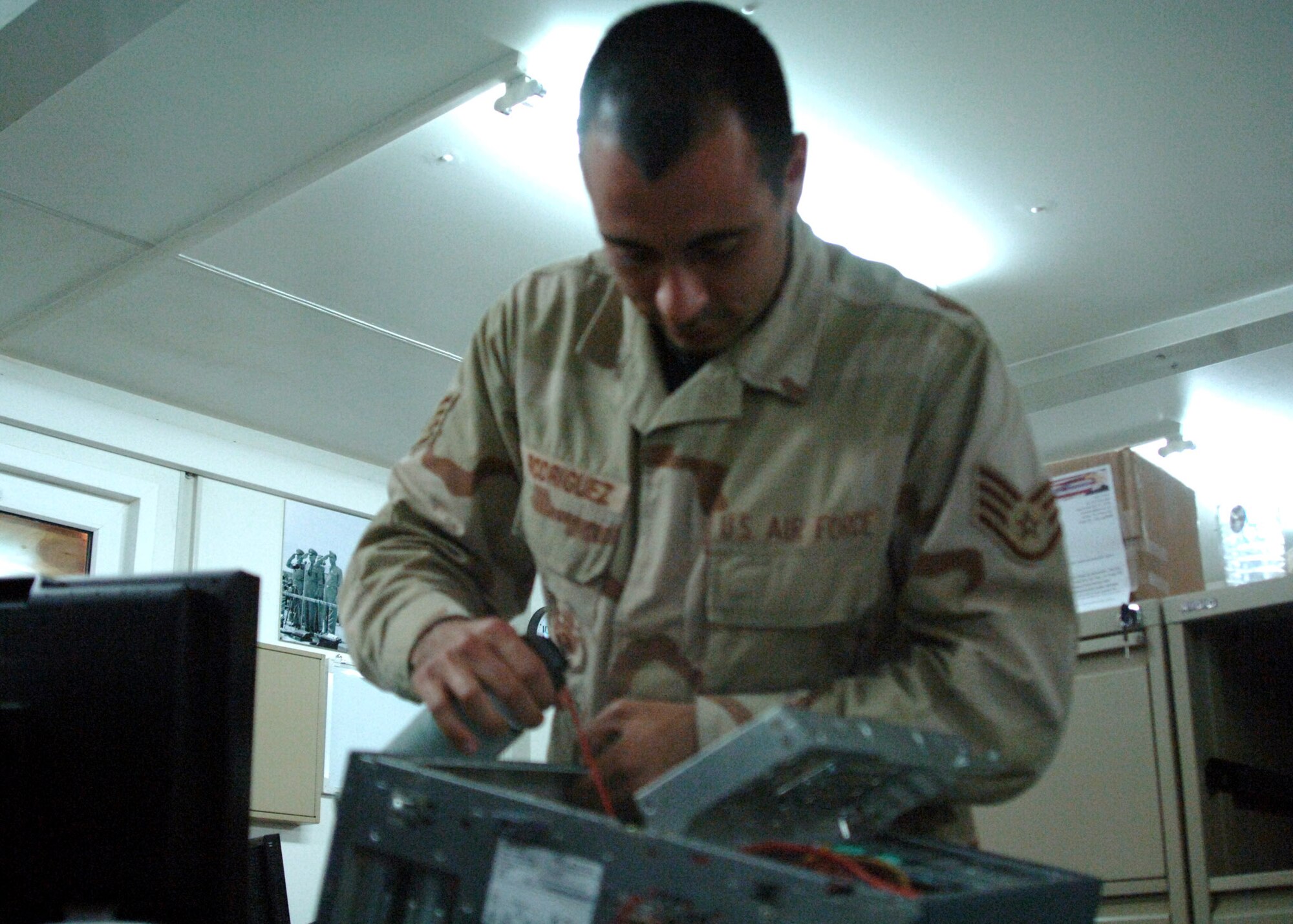 Staff Sgt. Mark Rodriguez cleans and troubleshoots computer equipment at Al Asad Air Base, Iraq. He deployed from the 71st Communications Squadron at Vance Air Force Base, Okla., and is assigned to the 438th Air Expeditionary Group. Sergeant Rodriguez is a computer systems specialist.  (U.S. Air Force photo/Capt. Ken Hall) 
