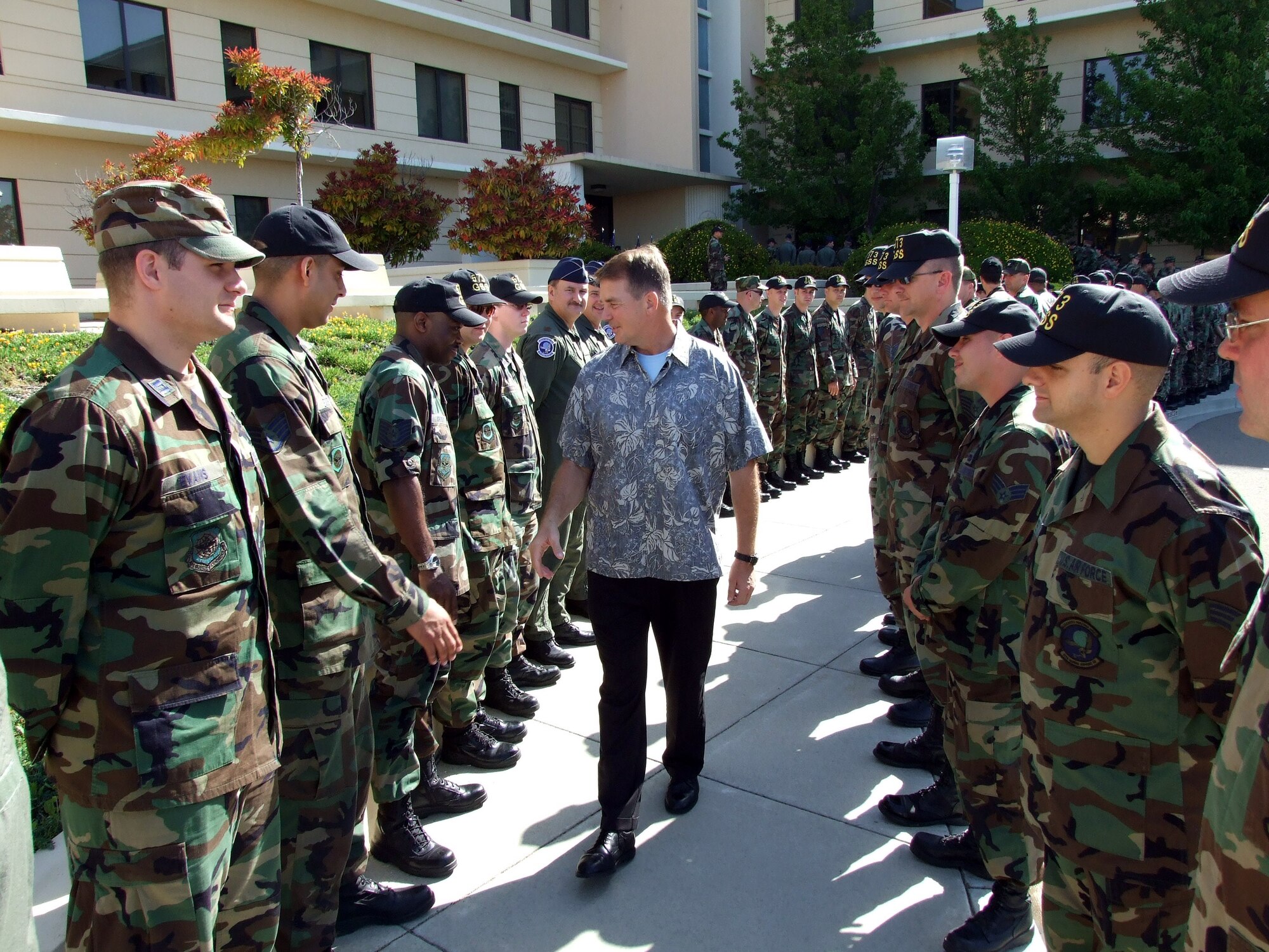 More than 200 Airmen from the 15th Expeditionary Mobility Task Force wrap around the sidewalk at the entrance of their headquarters to say farewell to Brig. Gen. Mark E. Stearns, 15th EMTF commander, April 27. General Stearns is deploying for a 120-day tour as the Director of Mobility Forces in Southwest Asia. (U.S Air Force photo by Staff Sgt. Ashkon Stone)