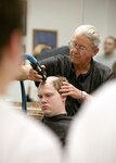 Doc Grimes gives Air Force basic trainee Robert Kraft his first military hair cut May 2 at Lackland Air Force Base, Texas. Trainee Kraft is assigned to the 323rd Training Squadron Flight 393. The flight is scheduled to graduate Air Force Basic Military Training on June 15. (U. S. Air Force photo/Robbin Cresswell)
