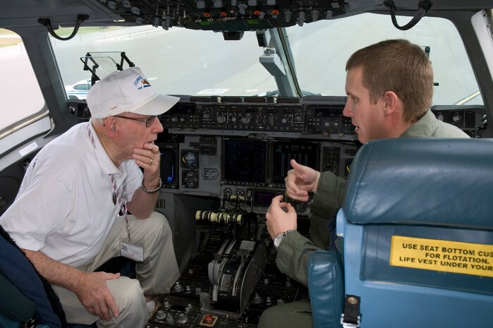 Ed Stiles, who was a crew chief with the Flying Tigers, talks with 1st Lt. Michael Campbell, 14th Airlift Squadron pilot, in the cockpit of a C-17 during the Flying Tigers reunion April 27. (U.S. Air Force photo/Senior Airman Sam Hymas)