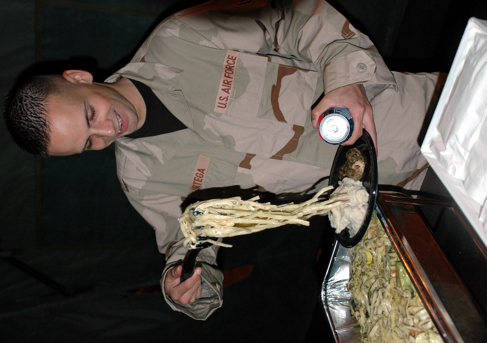 Airman 1st Class Angel Ortega, 571st Global Mobility Squadron, adds a heaping scoop of pasta to his plate during the Enlisted Combat Dining-In April 27. The event was sponsored by the Rising 6 and designed to increase Travis members’ morale, introduce some formal aspect of military social life and familiarize the enlisted corps with Air Force traditions. (U.S. Air Force photo by Staff Sgt. Candy Knight)