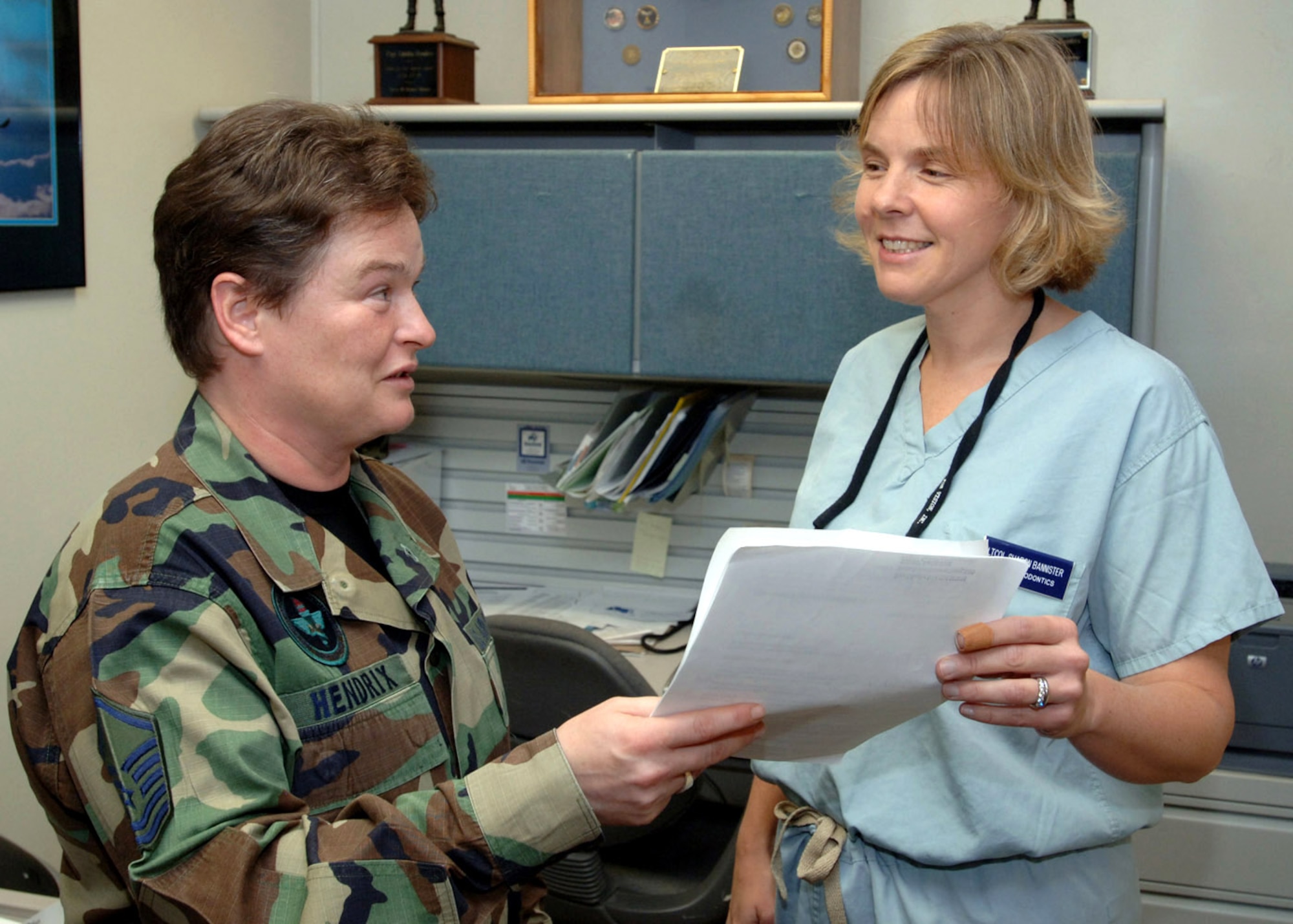 Master Sgt. Tabitha Hendrix and Lt. Col. Sharon Bannister discuss the daily patient roster at MacKown Dental Clinic April 24 at Lackland Air Force Base, Texas. Sergeant Hendrix was honored as the Child Advocate of the Year by the Child Advocates of San Antonio. Sergeant Hendrix is the NCO in charge of the Periodontics Flight, and Colonel Bannister is the deputy flight commander. (U.S. Air Force Photo/Tech. Sgt. Thomas Coney)