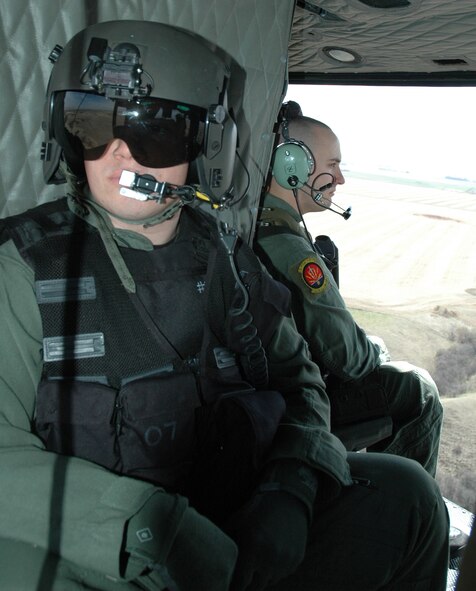 MINOT AIR FORCE BASE, N.D. -- Airman Timothy Merlin, 54th Helicopter Squadron flight engineer, scans the terrain during a security mission here April 26. As flight engineer, one piece of equipment Airman Hardin gets to use is the Forward Looking Infrared System, a high-tech camera with night vision and thermal heat-seeking capabilities. Airman Hardin uses the FLIR system to scan surrounding areas during missions. (U.S. Air Force photo by Airman 1st Class Wesley Wright)