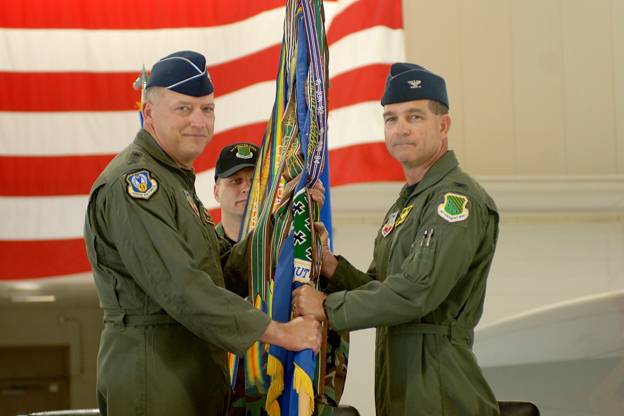 LANGLEY AIR FORCE BASE, Va. -- Col. Mark A. Barrett, the new 1st Fighter Wing commander, accepts the 1st Fighter Wing flag from Lt. Gen Gary North, commander of 9th Air Force and U.S. Air Forces Central, during the change of command ceremony here April 30. (USAF Photo by Tech Sgt Levi Collins)