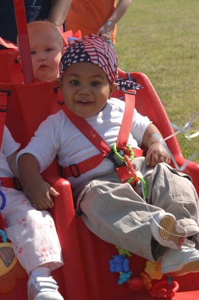 Dacien Owens, 13 months, gives a big smile to the crowd at the Child Development Center's parade April 27 in honor of the Month of the Military Child. (U.S. Air Force photo by Airman First Class Domonique Simmons)