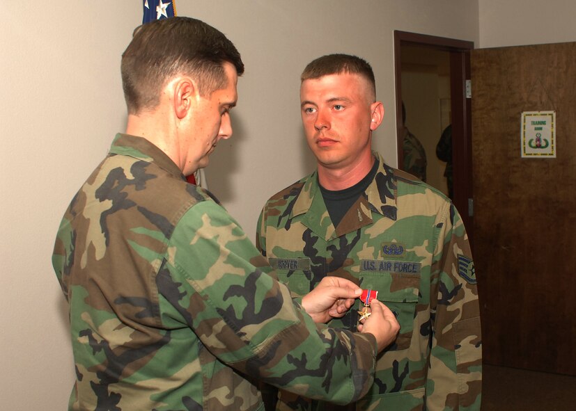 Col. Timothy Ray, 7th Bomb Wing commander, presents the Bronze Star Medal to Staff Sgt John Hoover, 7 Civil Engineering Squadron, May 1. Sergeant Hoover is an Explosive Ordinance Devise Team Leader. (U.S. Air Force photo by: Airman 1st Class Felicia Juenke)