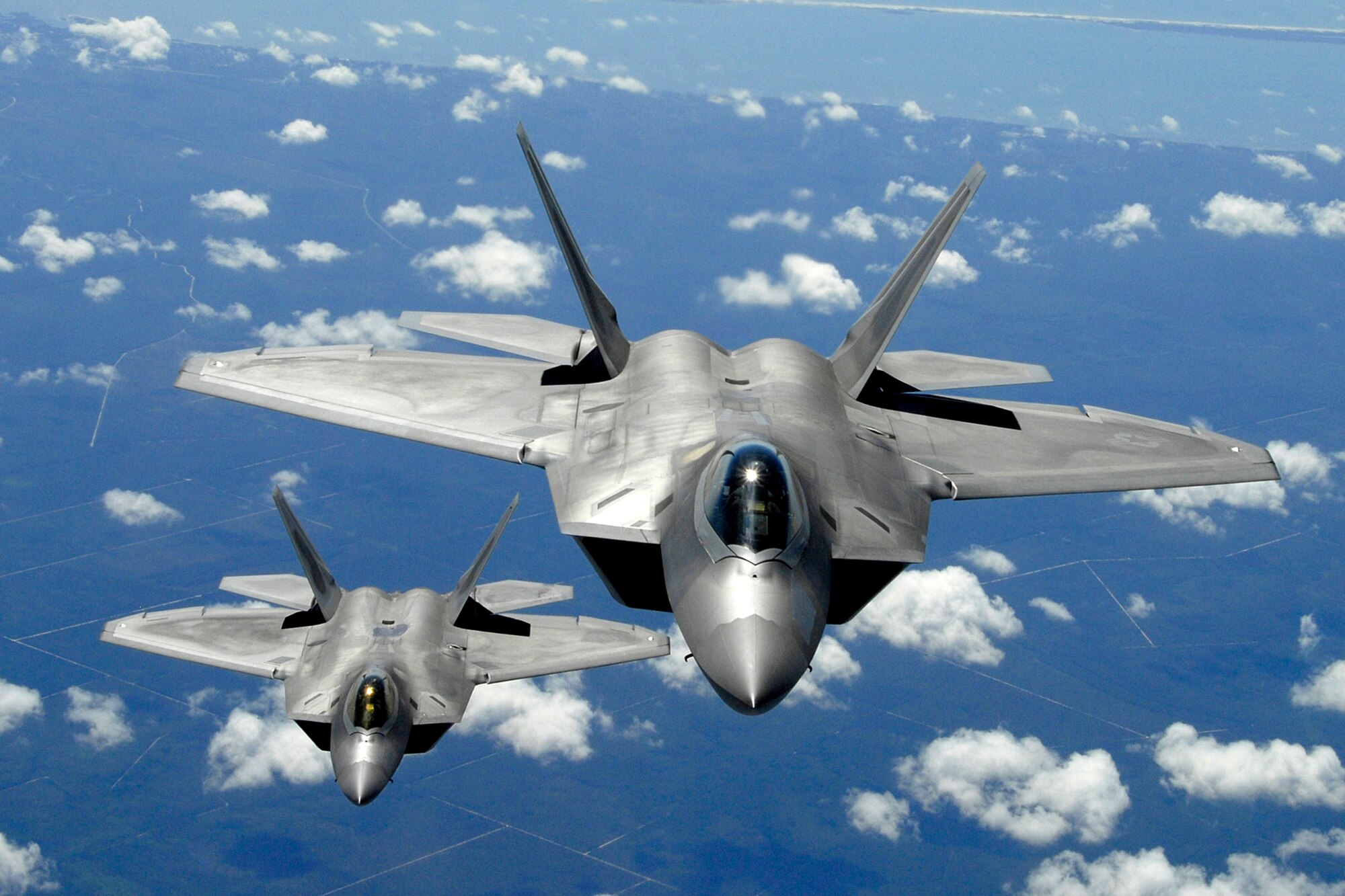 Two F-22 Raptors from Tyndall Air Force Base, Fla., fly in formation. Its combination of stealth, supercruise, maneuverability, and integrated avionics, coupled with improved supportability, represents an exponential leap in warfighting capabilities. The F-22 performs both air-to-air and air-to-ground missions allowing full realization of operational concepts vital to the 21st century Air Force. (U.S. Air Force photo/Senior Master Sgt. Thomas Meneguin)

